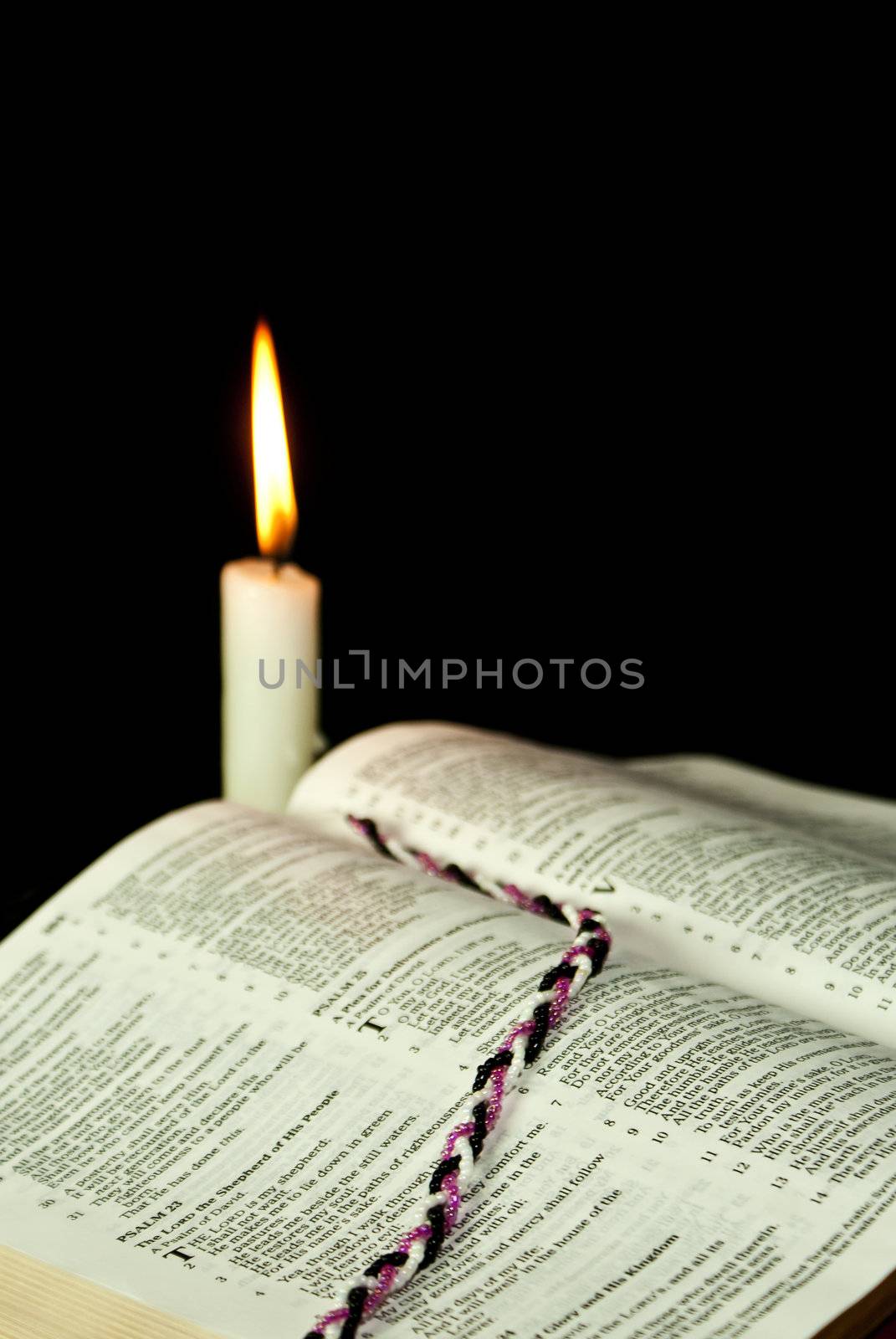 Open Bible with burning candle by AndreyKr