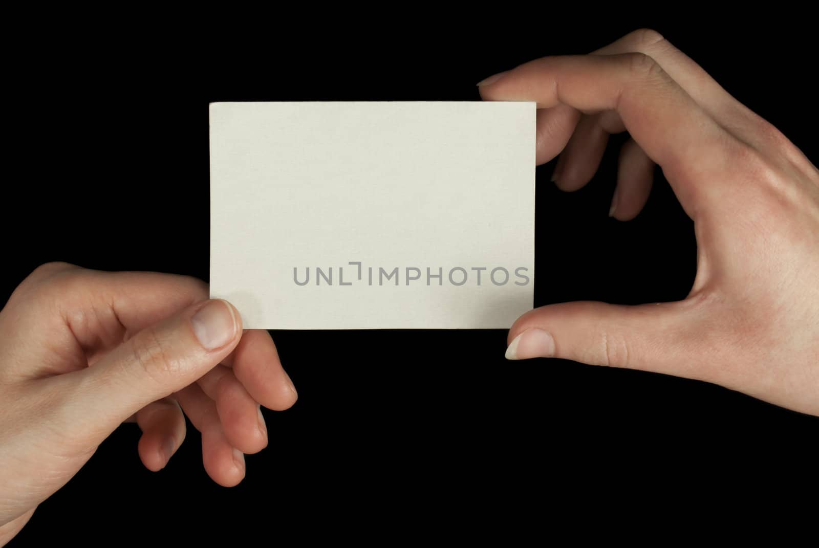 Hands holding a white card isolated on black background