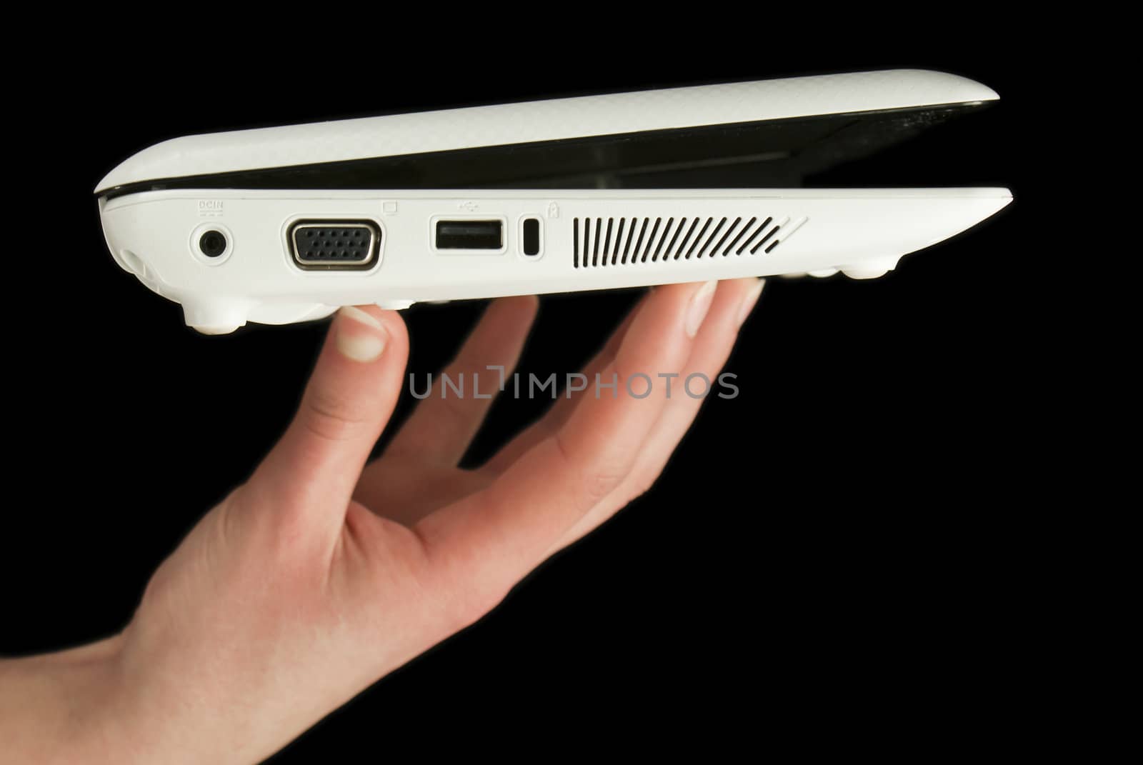 Netbook held by fingers isolated on black