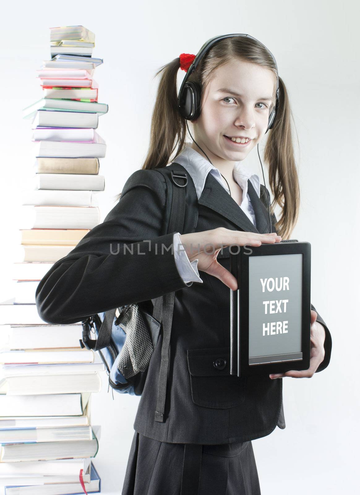Teen girl with electronic book with a stack of printed books behind
