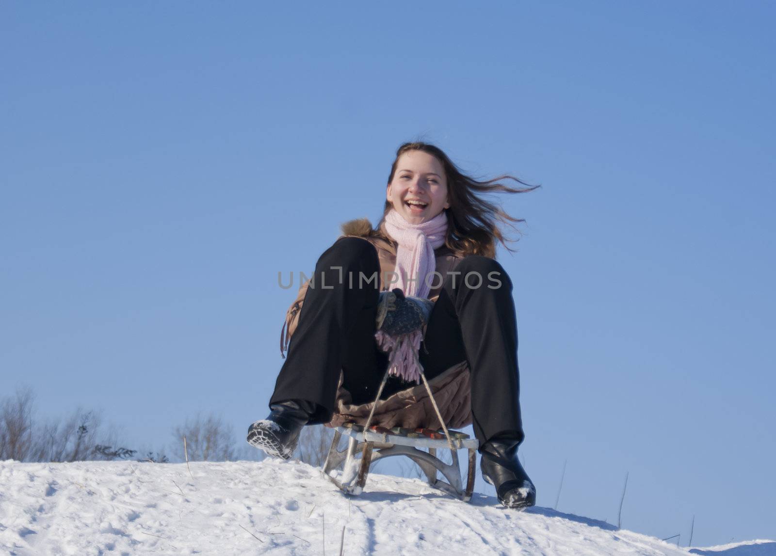 Teen girl sledding from a hill by AndreyKr
