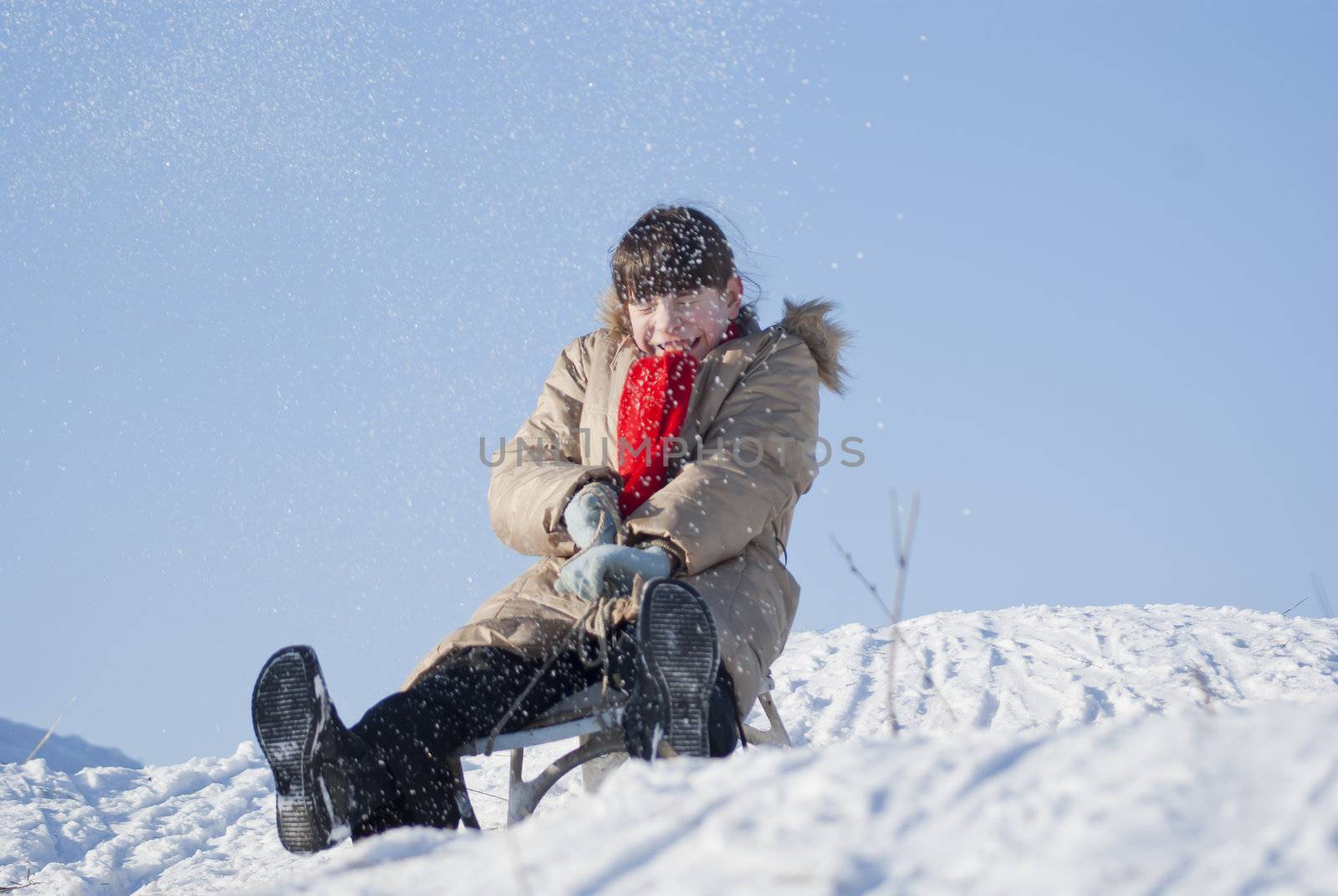 Teen girl sledding from a hill by AndreyKr