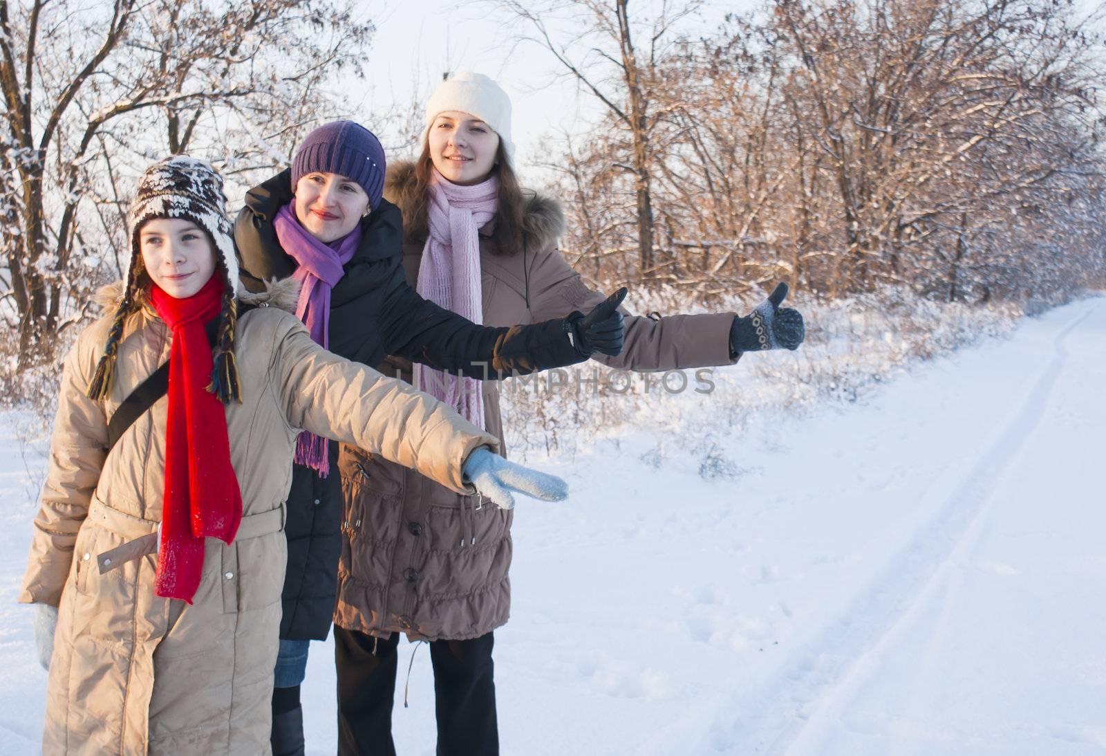 Three teens hitchhiking at the snowy road by AndreyKr