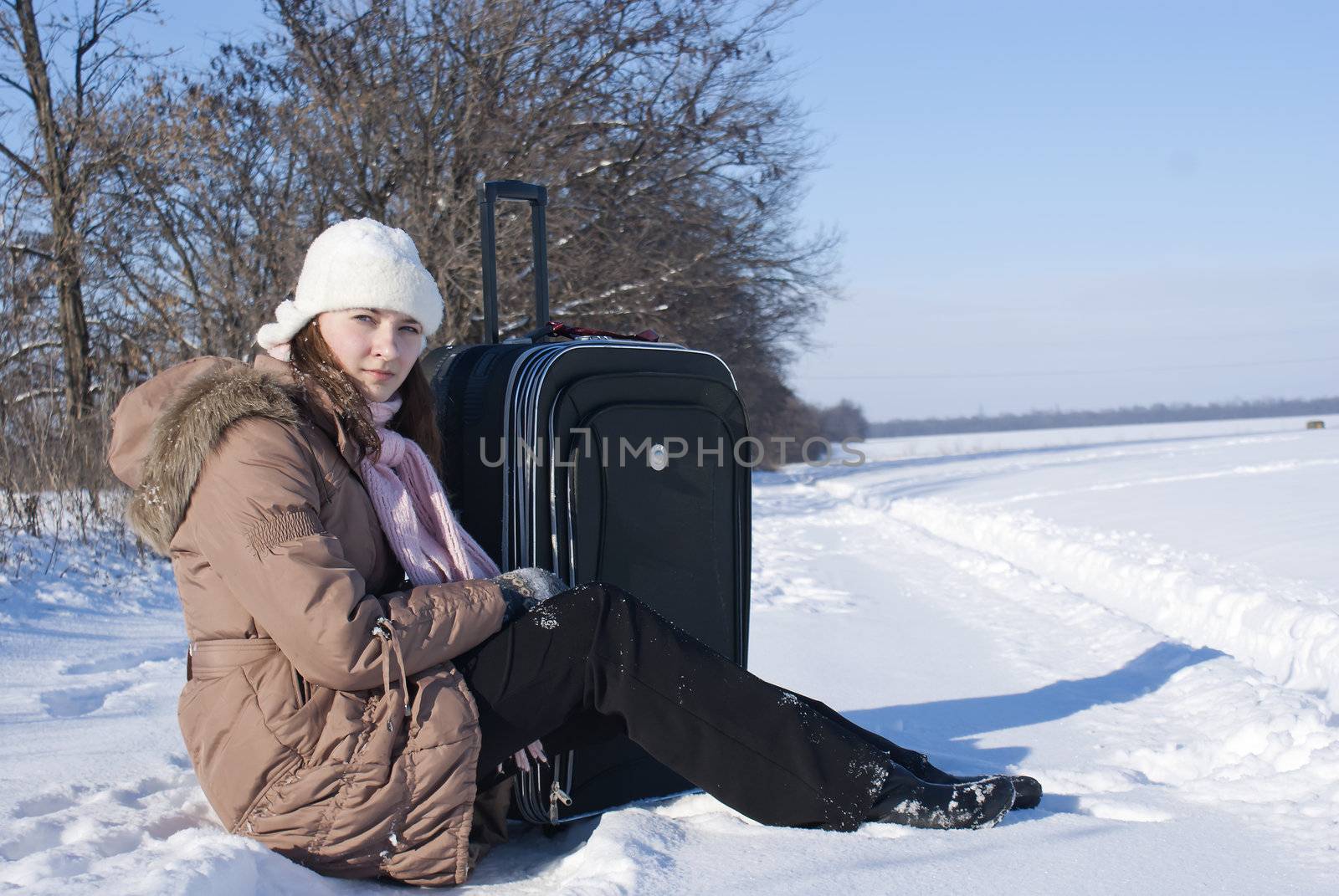 Teen girl with a suitcase outdoors at winter time by AndreyKr