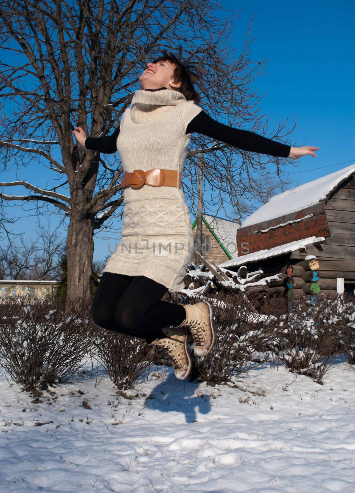 Young lady jumping at winter time