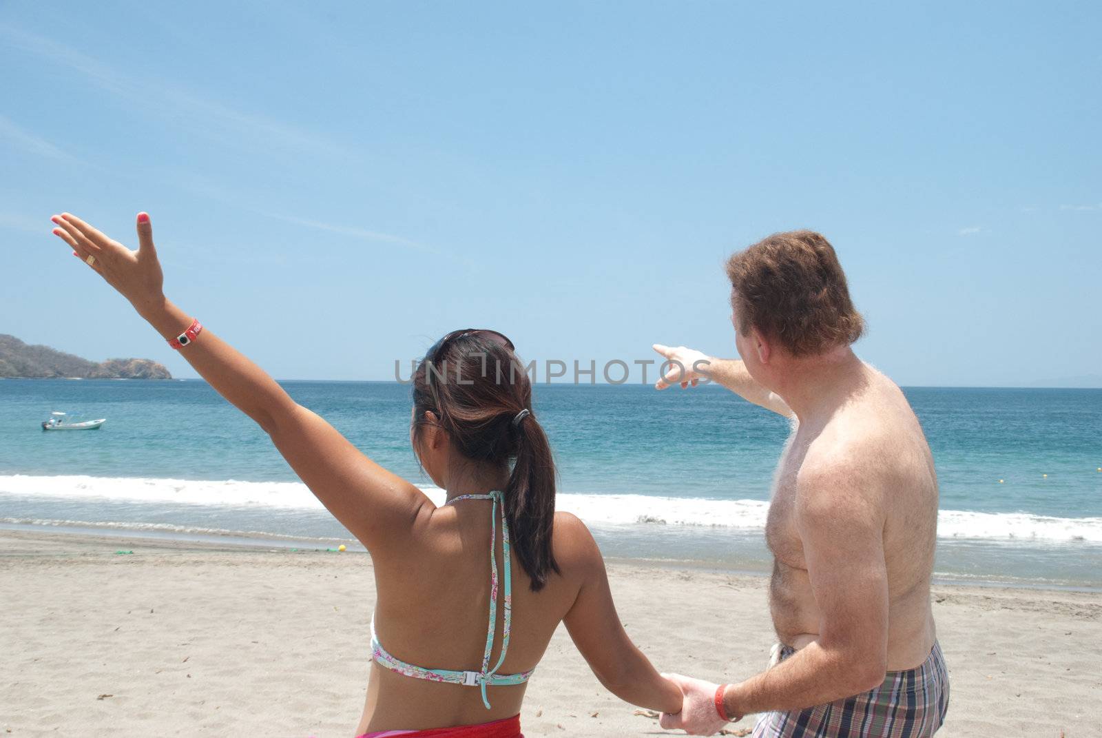 Couple enjoys the view at the beach by dimasb