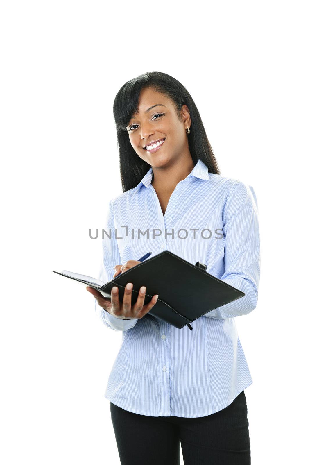 Young smiling  black woman writing in leather portfolio folder