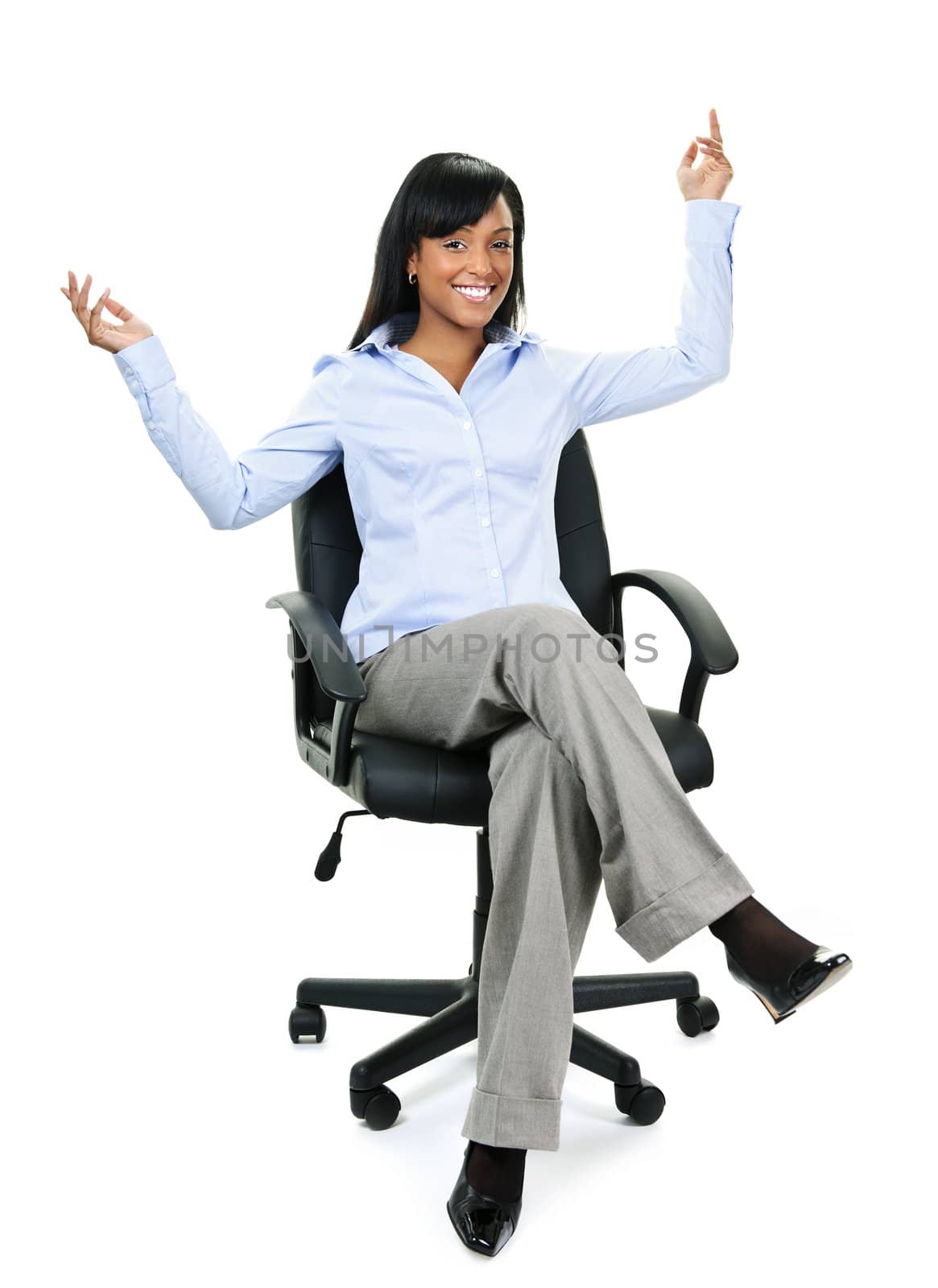 Young excited black businesswoman sitting in leather office chair