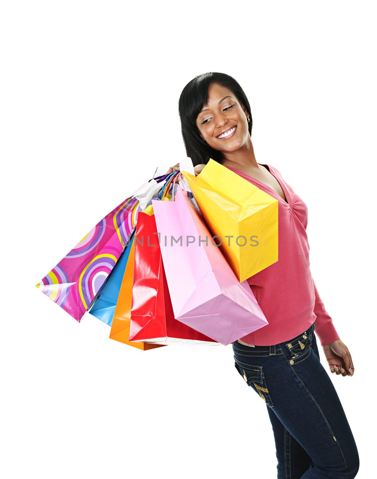 Young joyful black woman holding shopping bags