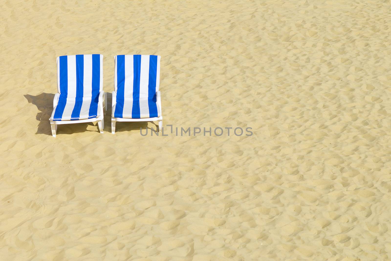 two empty chairs on a beach