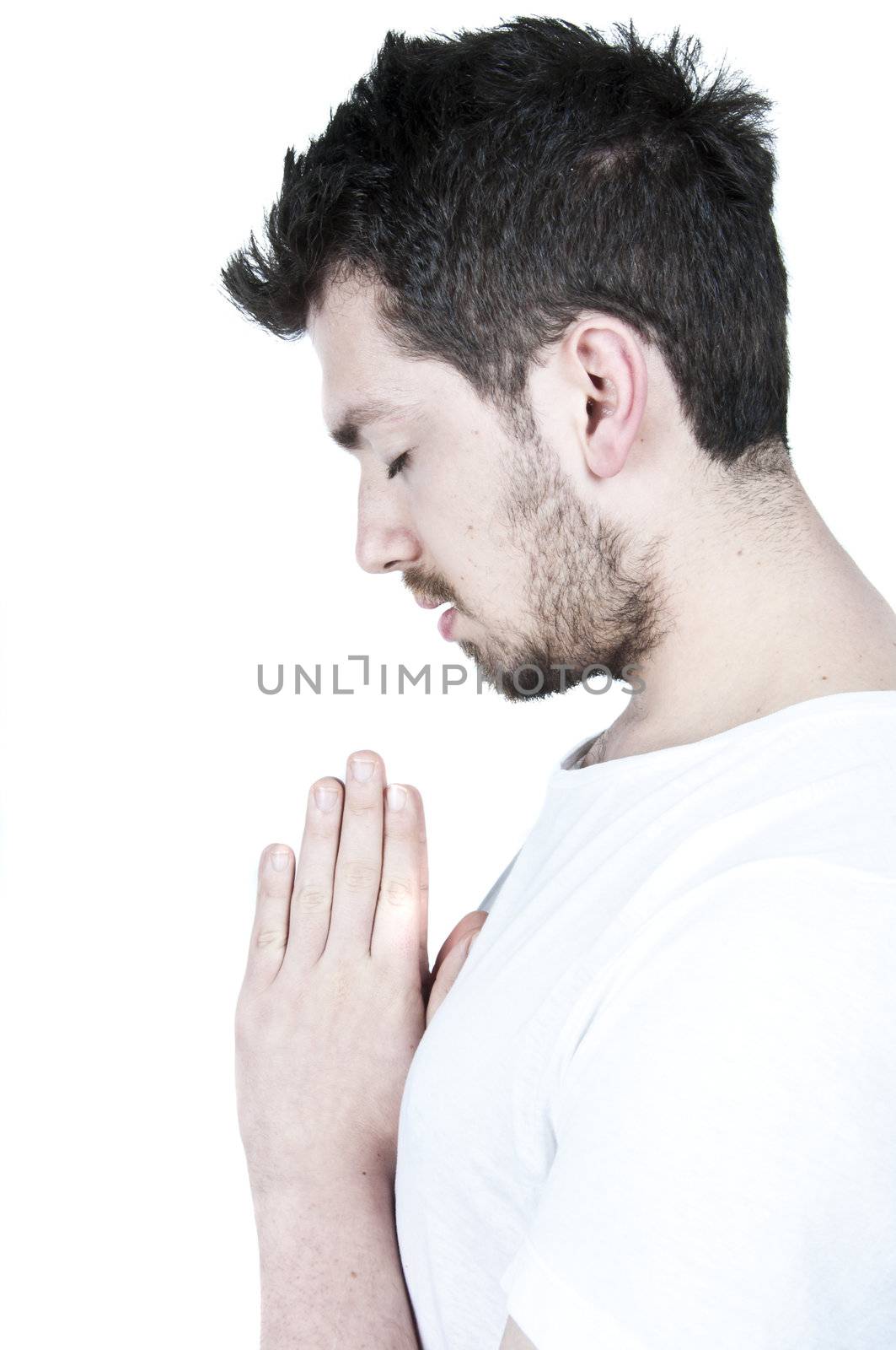 Praying young bearded man on white background