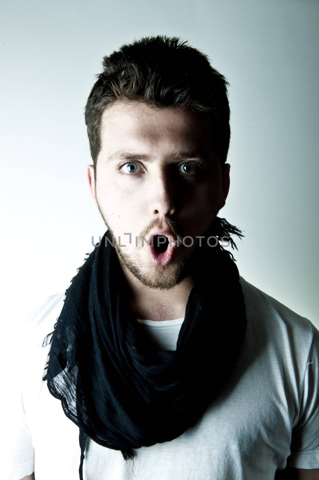 Portrait of amazed young man with blue eyes 