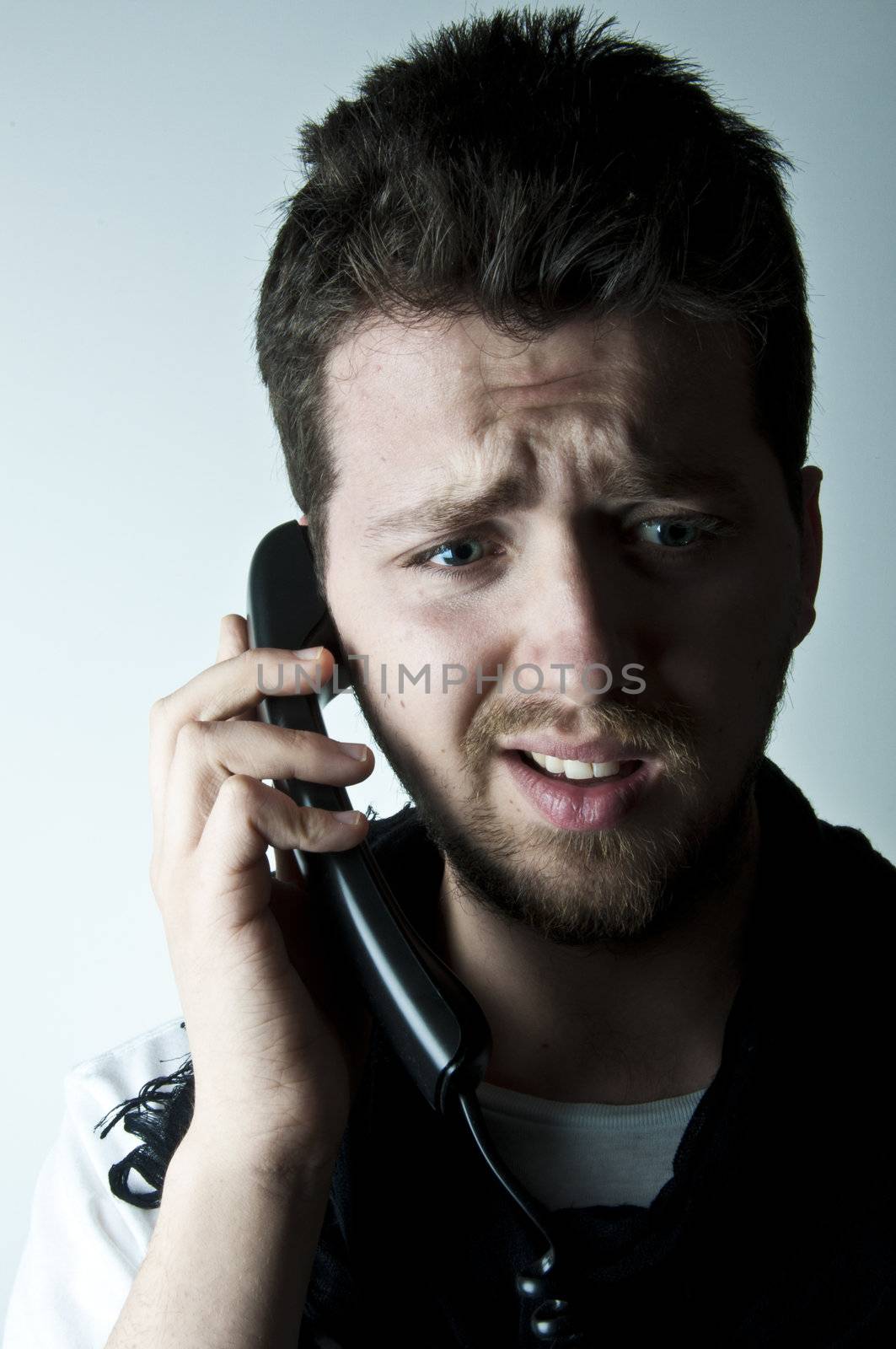 Young man talking on a wired phone