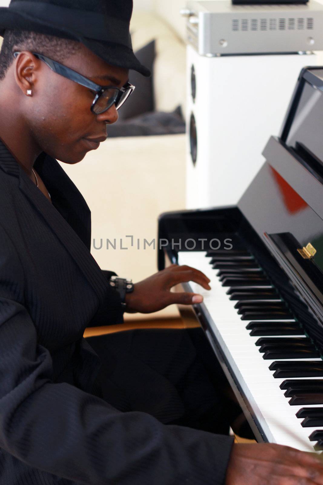 Black musician plays the piano - photographed from the side