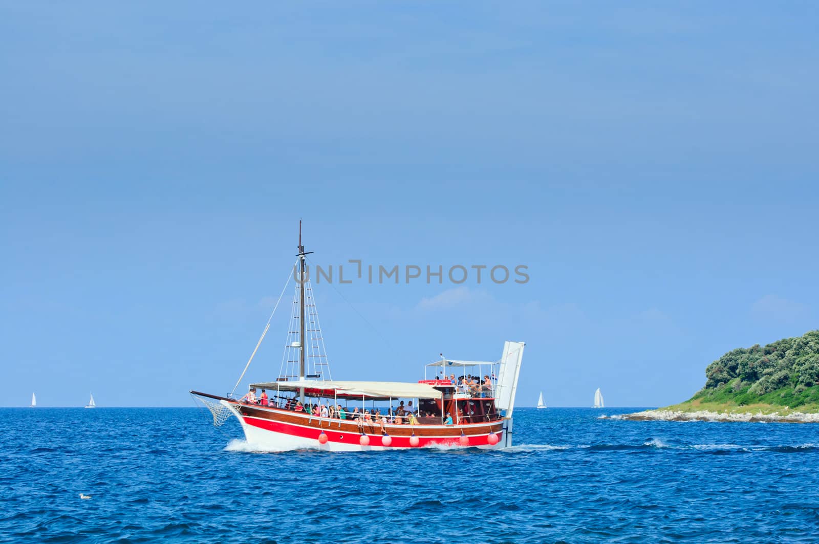 Red Tourists floating on a boat on the sea of Adriatic