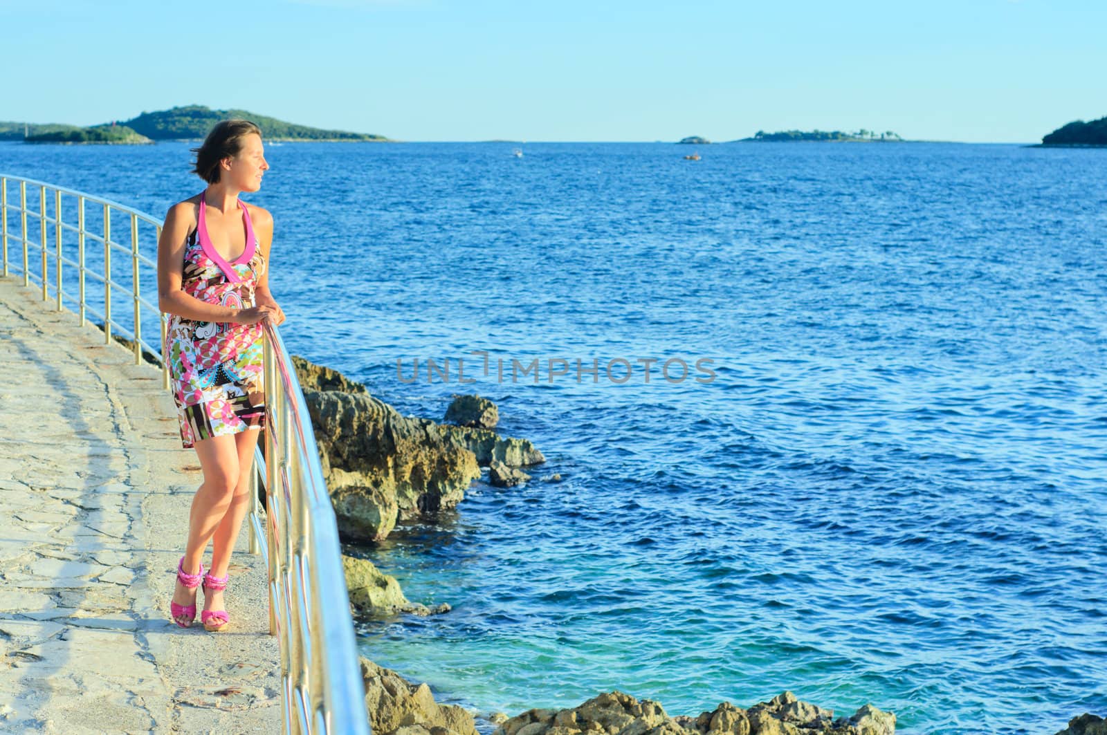 Beautiful young woman looking over the Adriatic Sea. Croatia