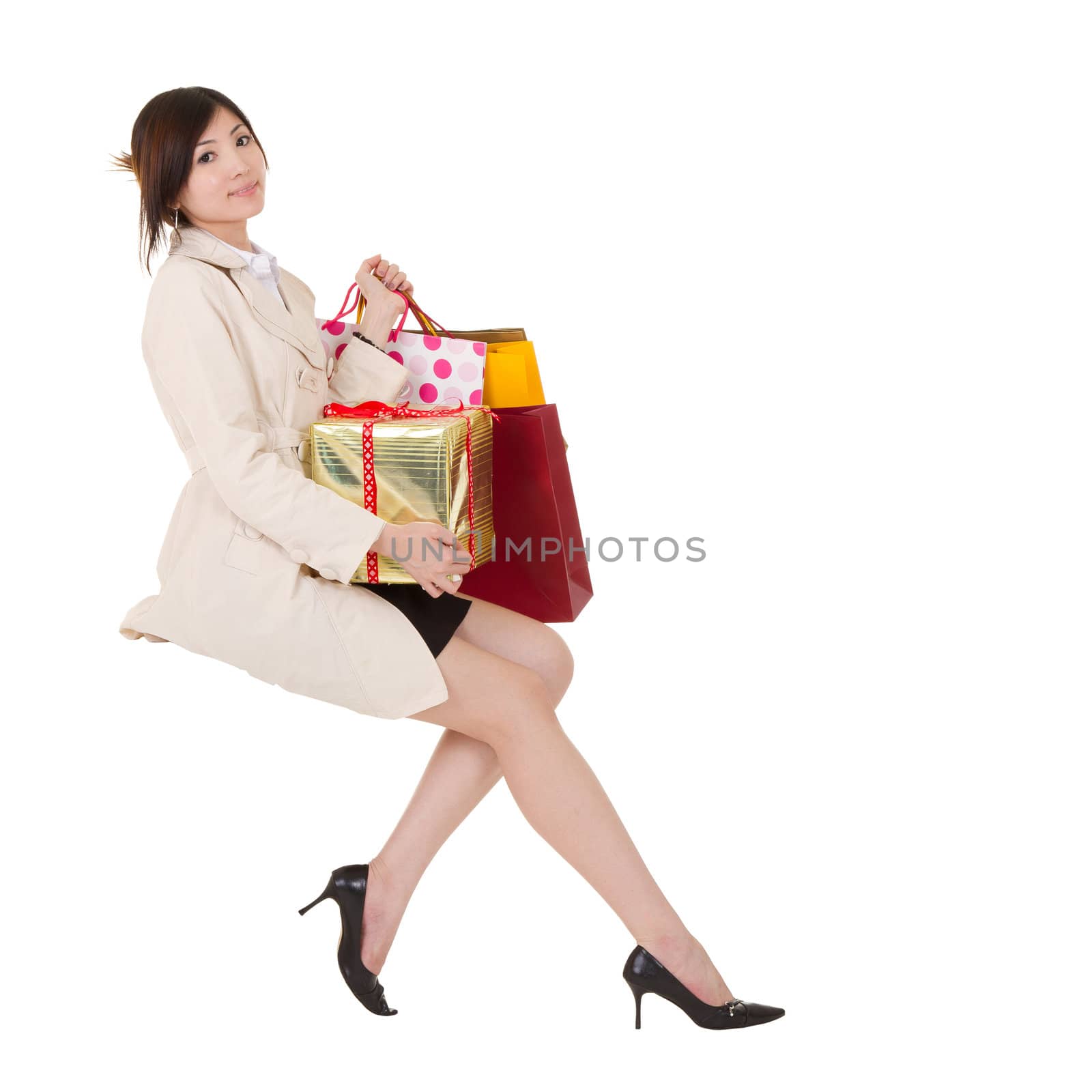 Isolated sitting shopping woman holding bags and gift box, full length portrait on white background.