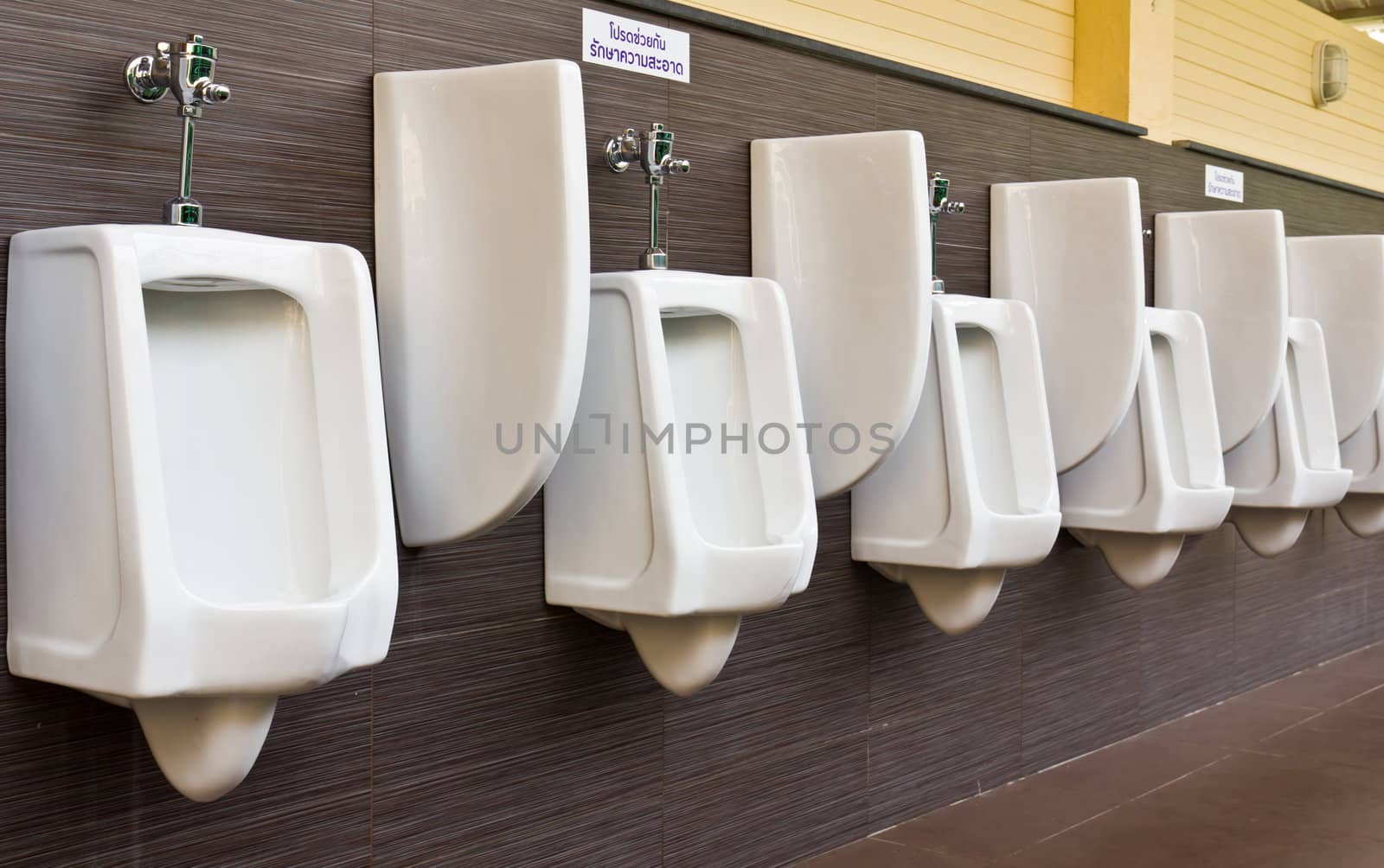 Row of white porcelain urinals in public toilets