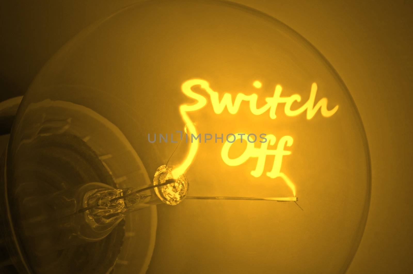Close up of an illuminated yellow light bulb filament spelling the words switch off