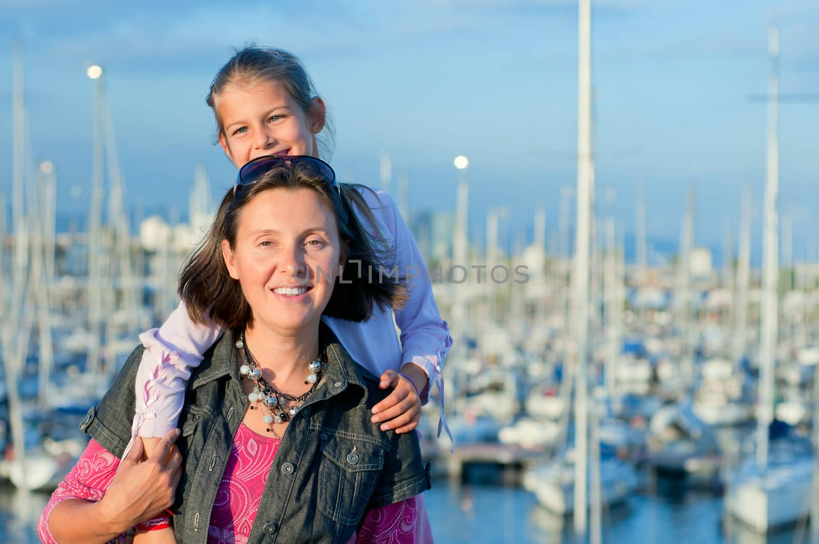 Closeup Portrait of a cute girl with her mother in the background of yachts