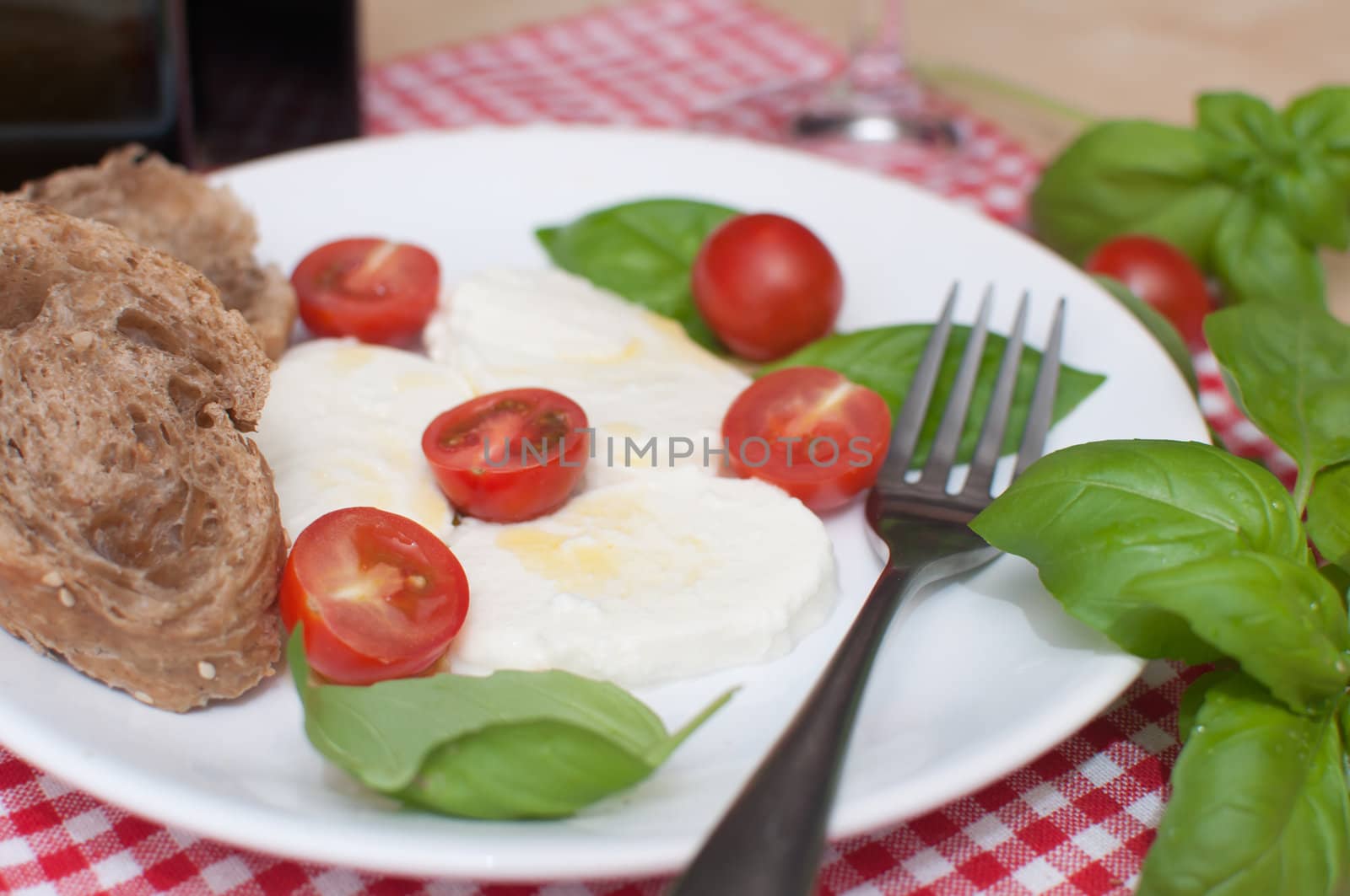Caprese - Mozzarella Cheese With Tomatoes and Basil on Table