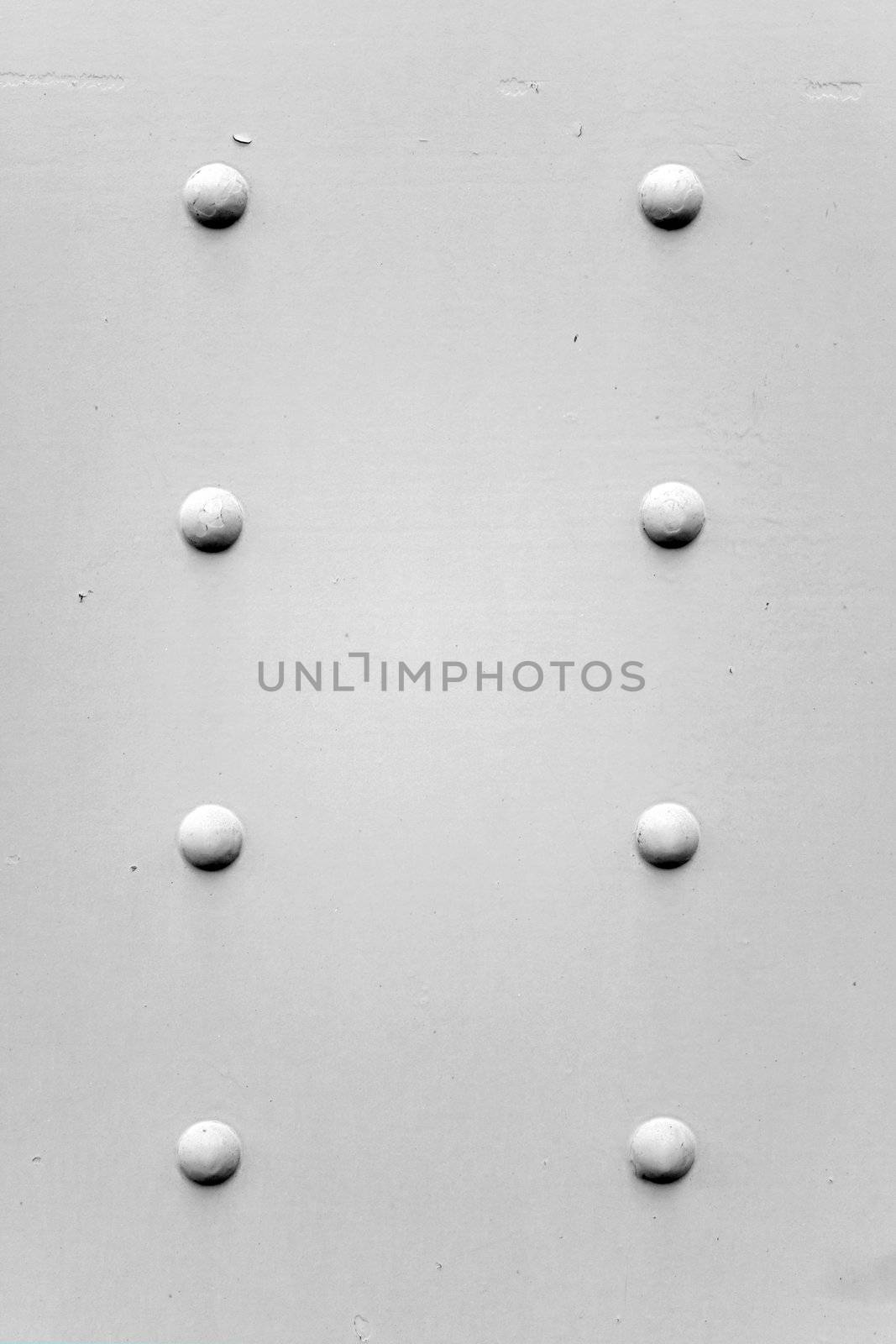 A painted metal background texture with four rusted bolts or rivets in black and white.