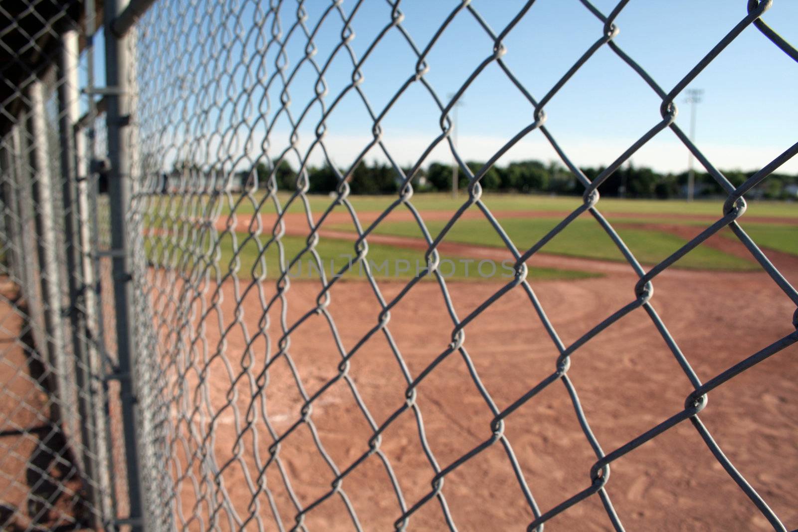 A view from behind the fence at a small baseball field.
