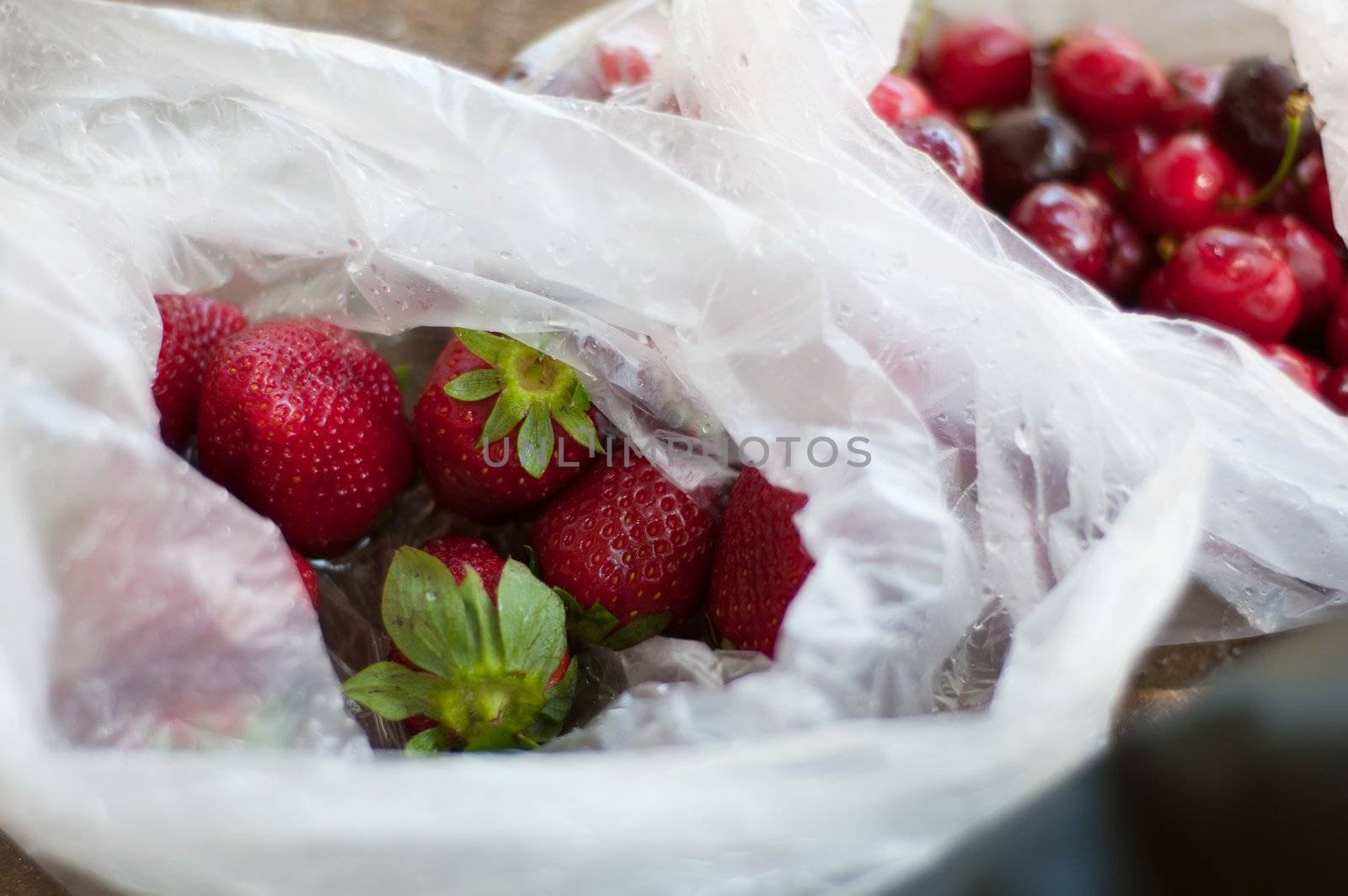 Ripe trawberry and cherry in plastic bag