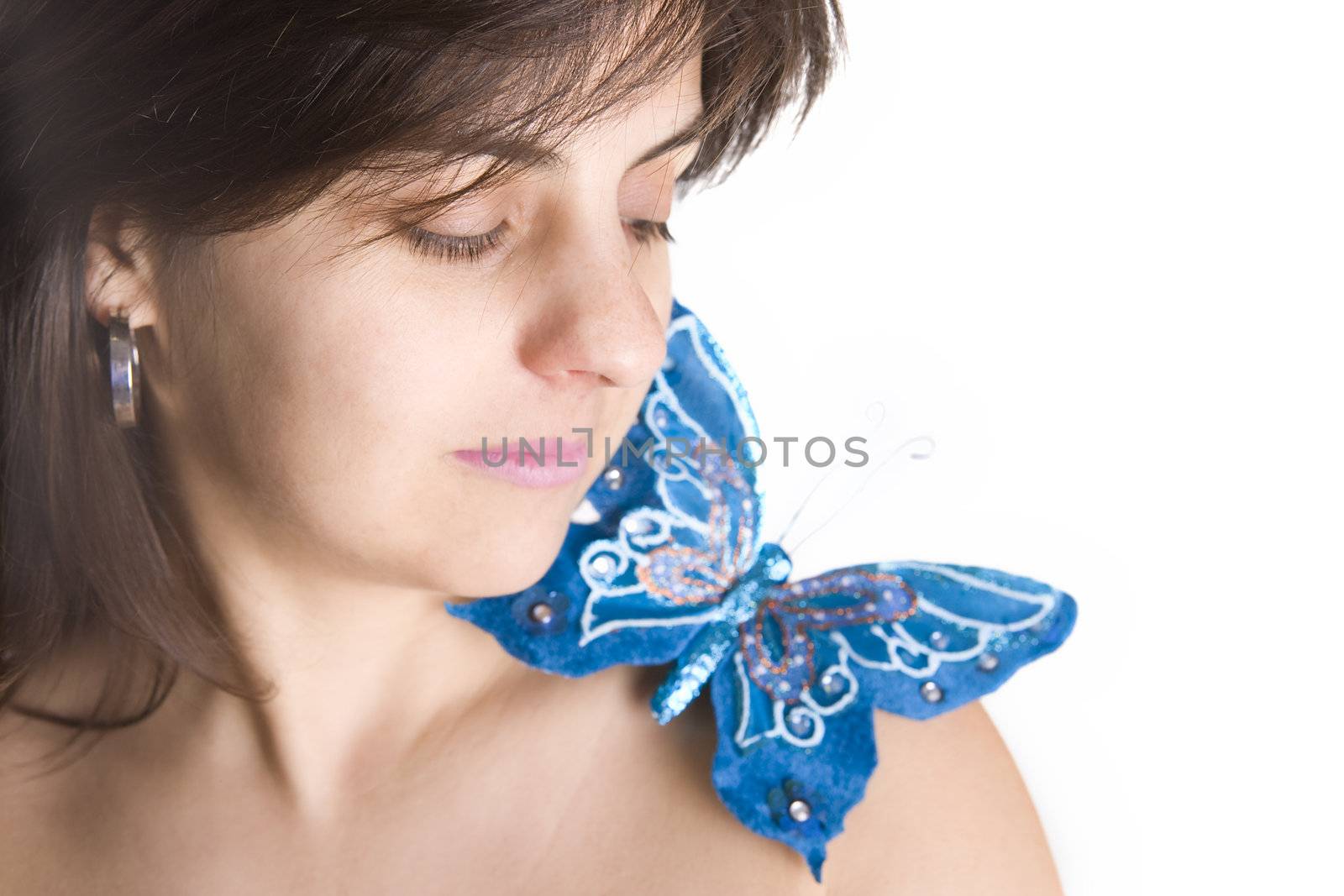 beautiful young woman with blue butterfly in her naked shoulder - focus on the eye
