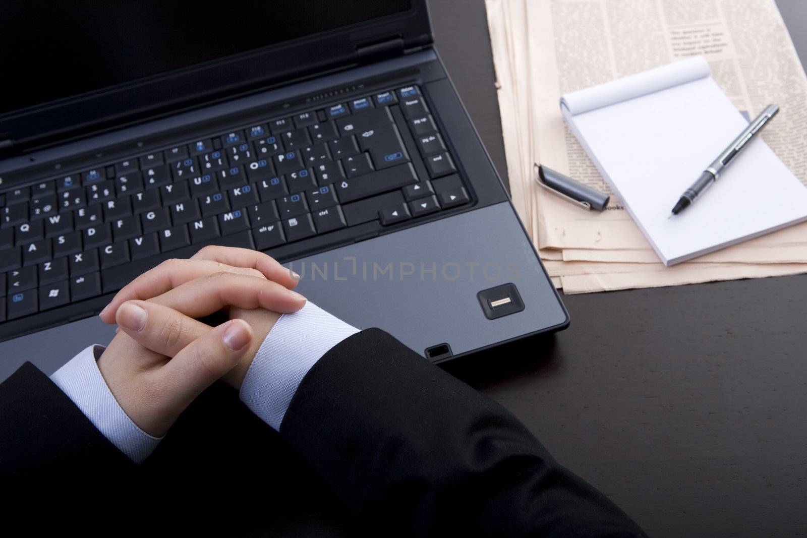 businesswoman with hands crossed iin front of laptop computer by mlopes