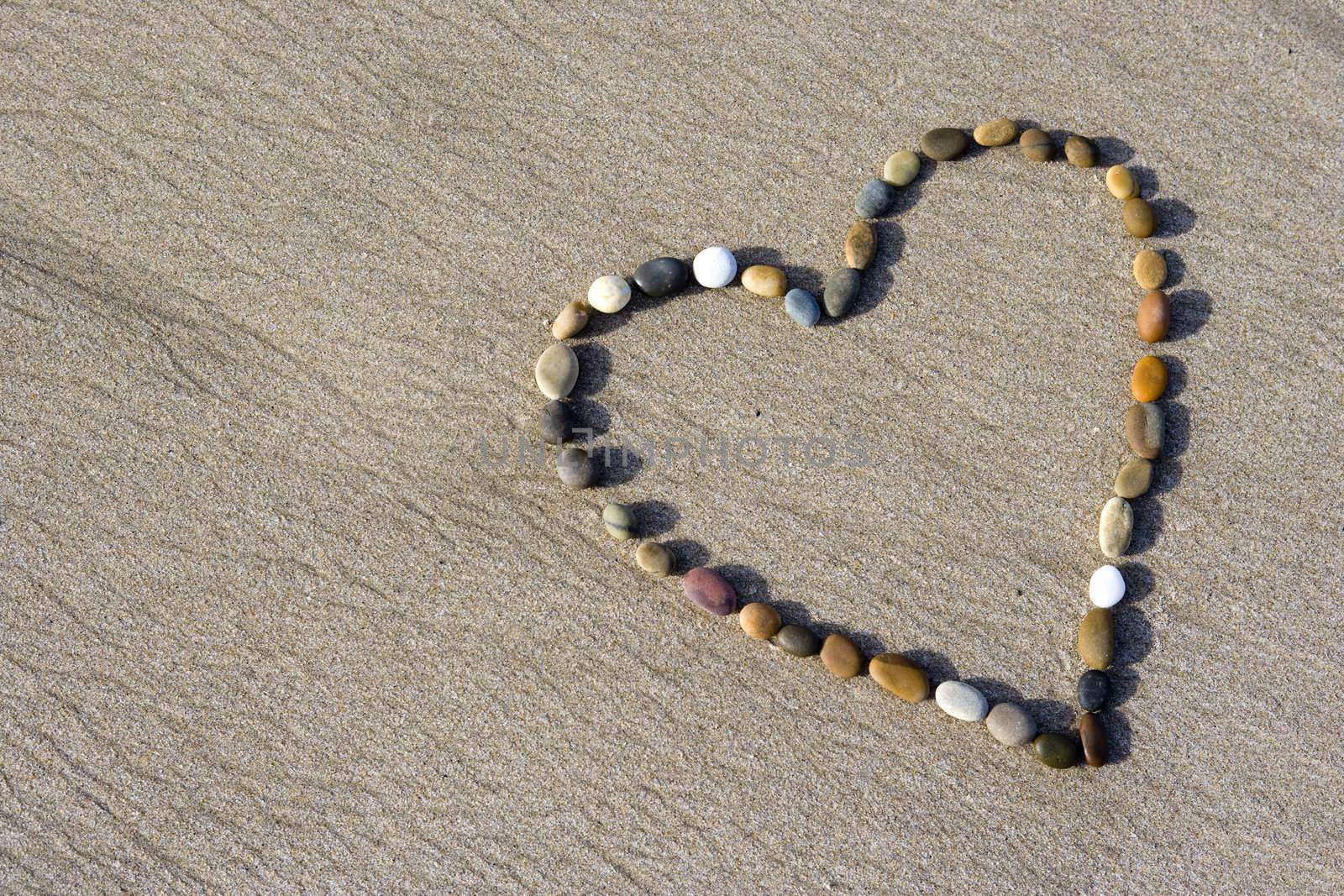 Heart made with small stone in the wet sand by mlopes