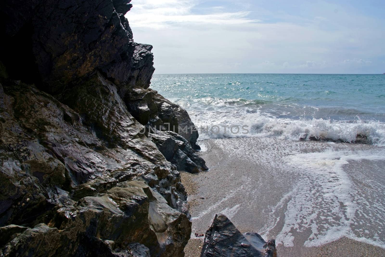 The sea beating against a hard stone cliff