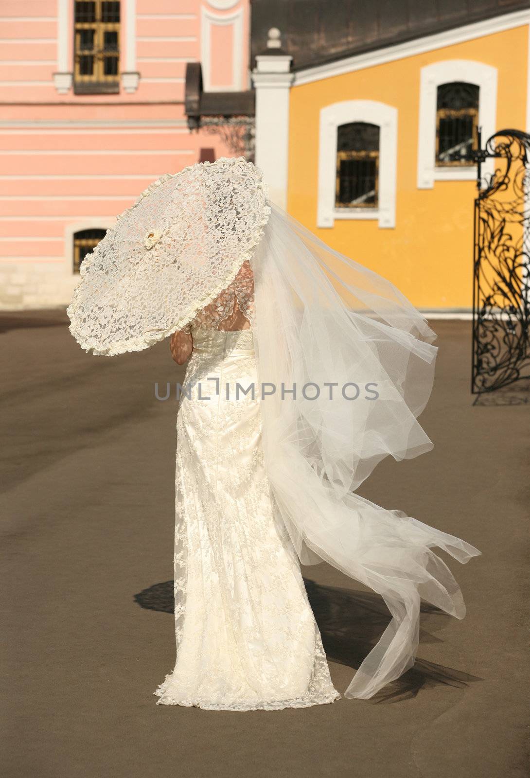 The bride with a umbrella in a sunny day