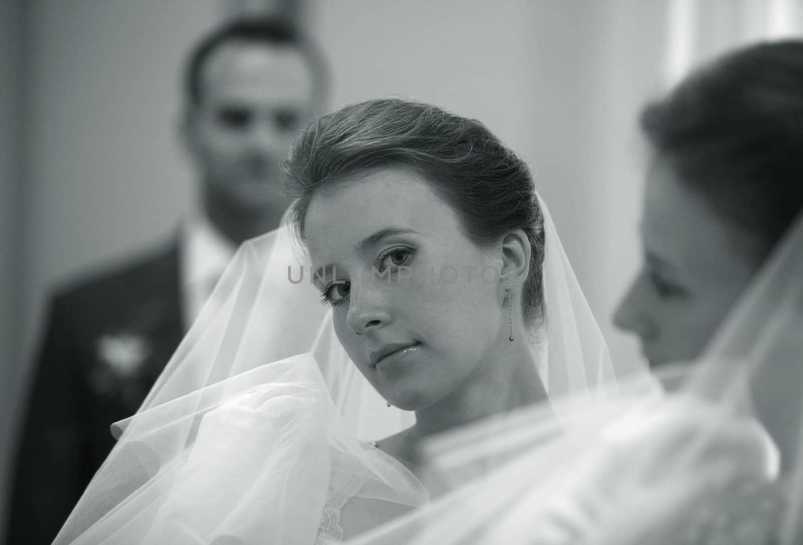 The beautiful young bride and the groom are reflected in a mirror