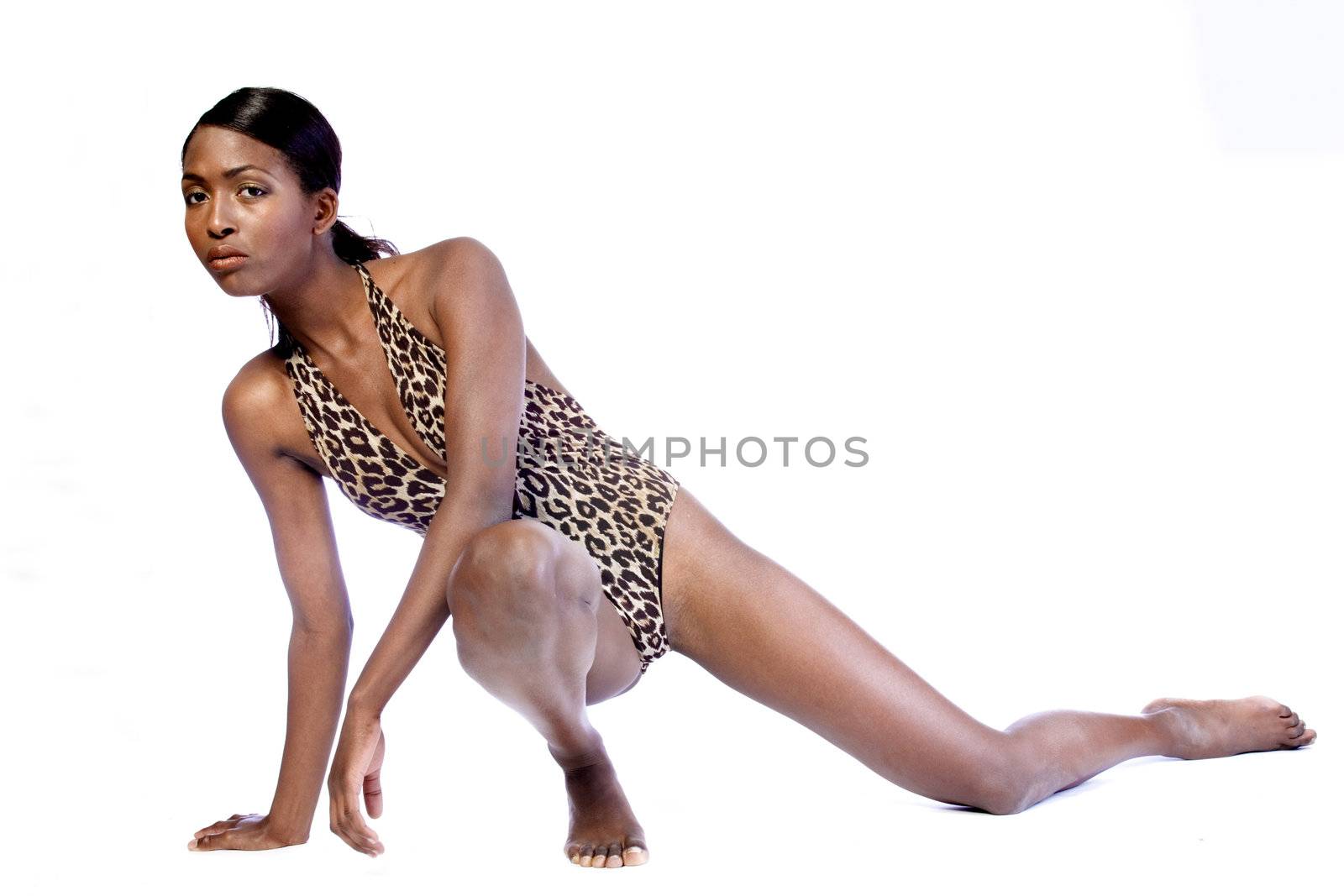 A beauty portrait taken from an african model in the studio stretchin in her bathing suit