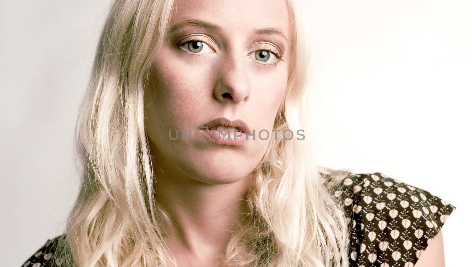 Beautiful blond model in the studio looking angry