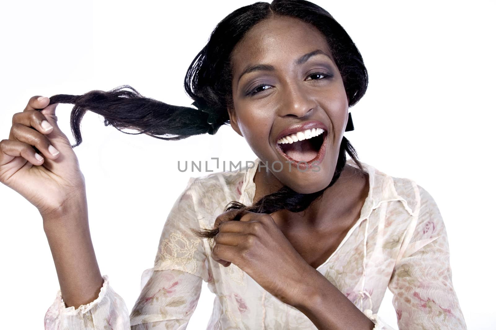 A beauty portrait taken from an african model in the studio playing with her hair