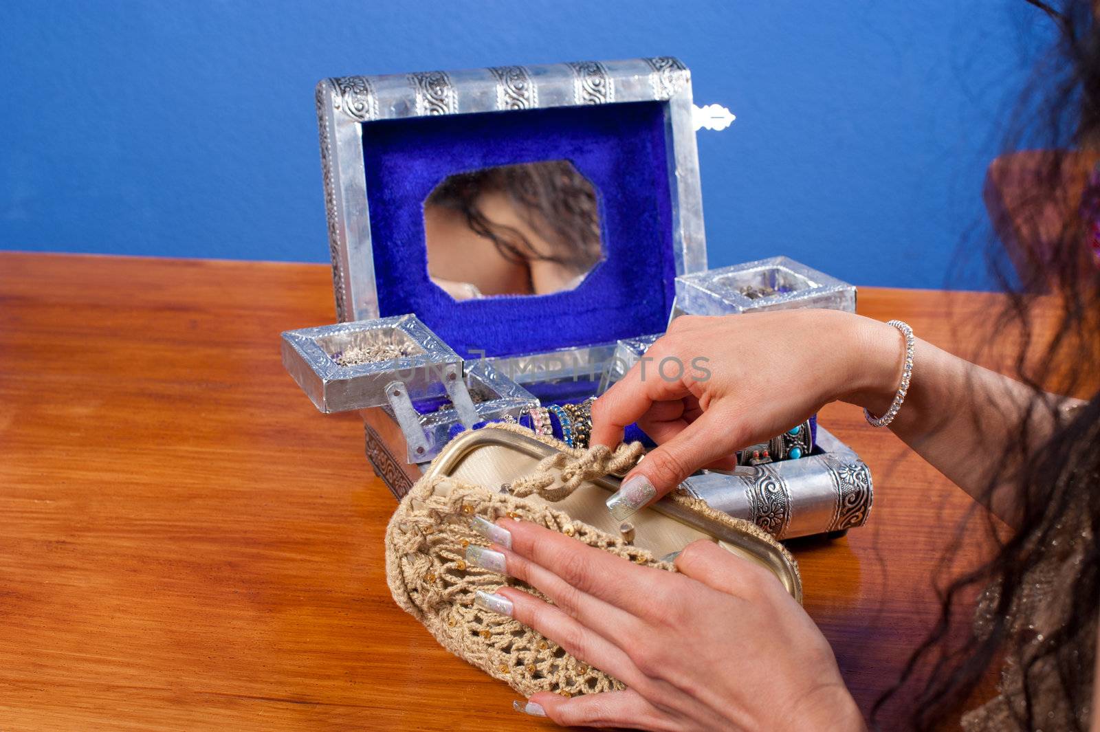 Female hands and her reflection in the mirror of a beautiful jewel case