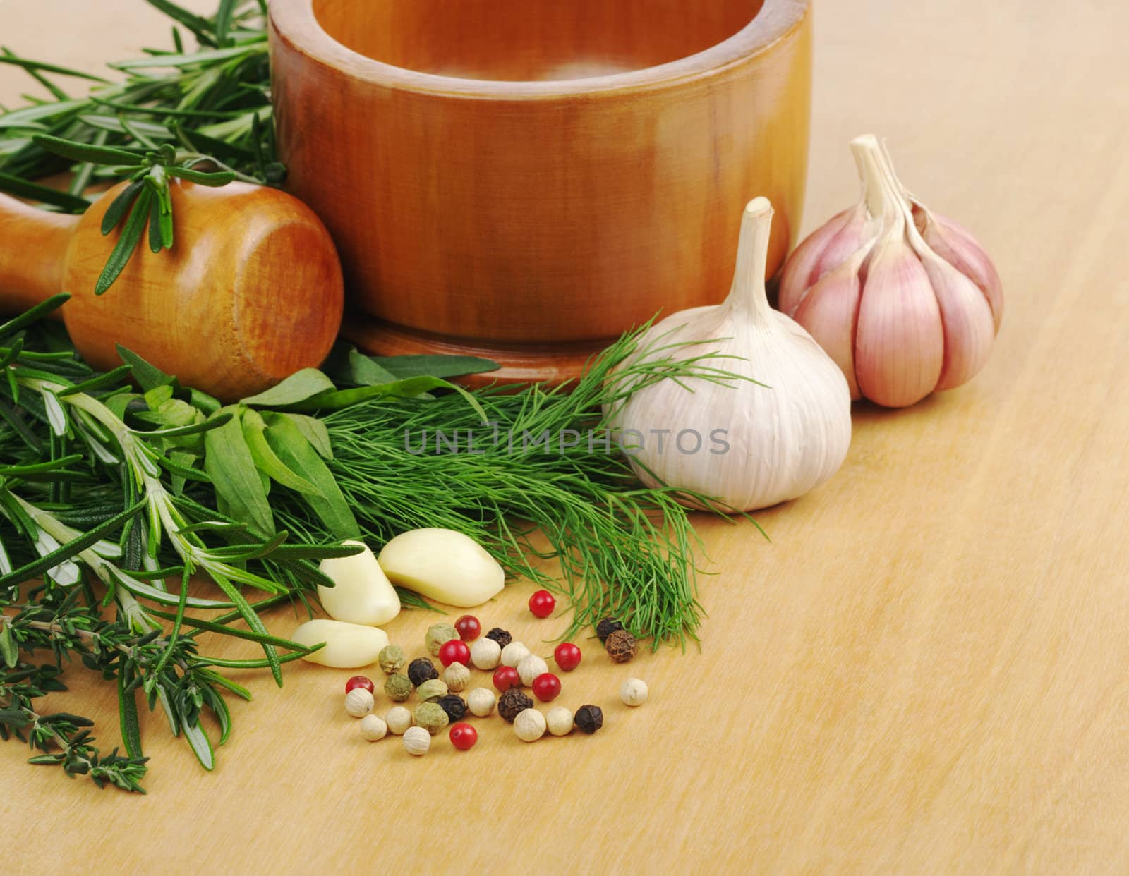 Mortar with garlic, peppercorns, dill, rosemary and thyme on wooden board (Selective Focus)  