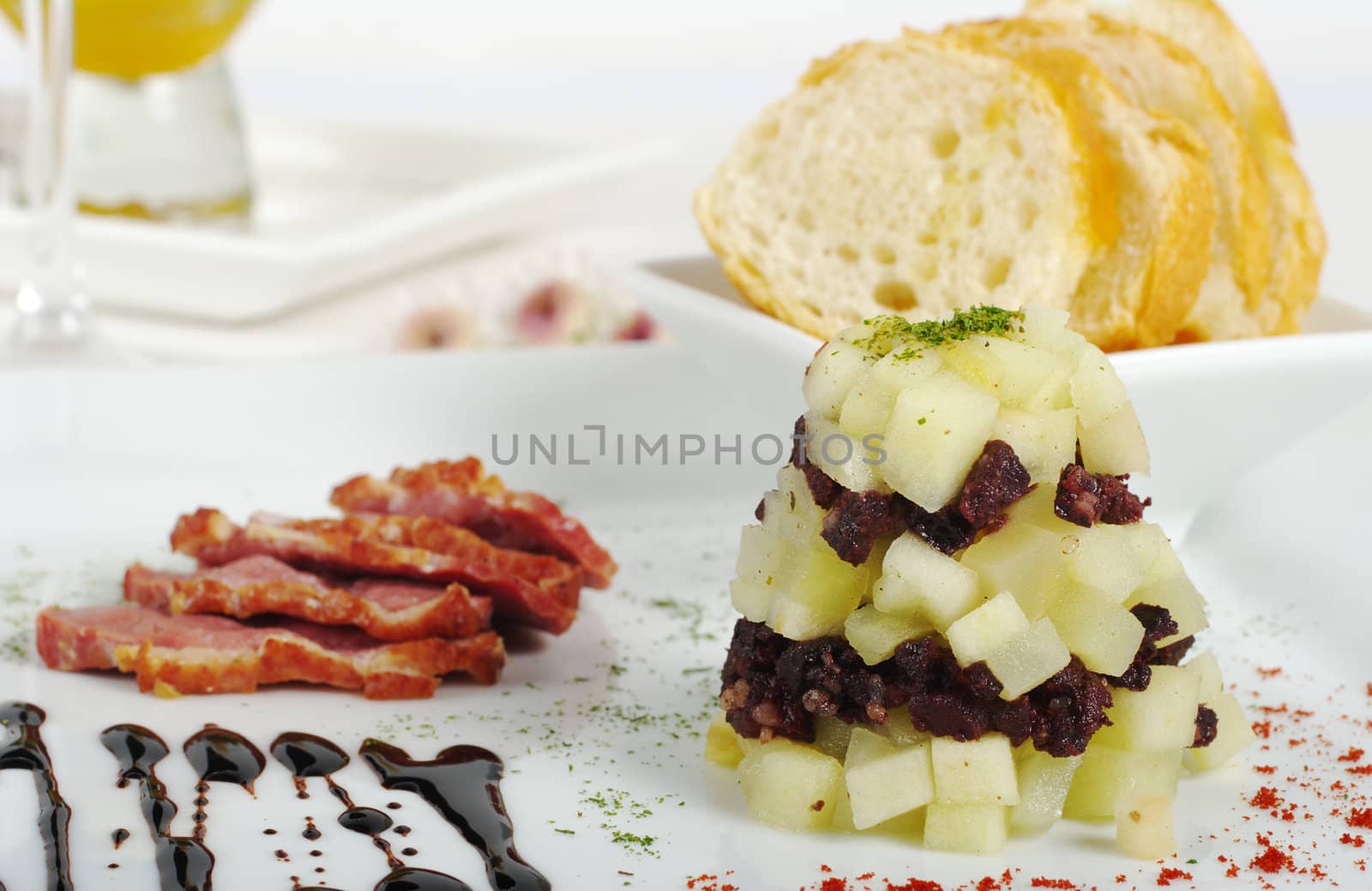 Appetizer: Pile of apple and sausage pieces with ham and baguette slices (Selective Focus) 