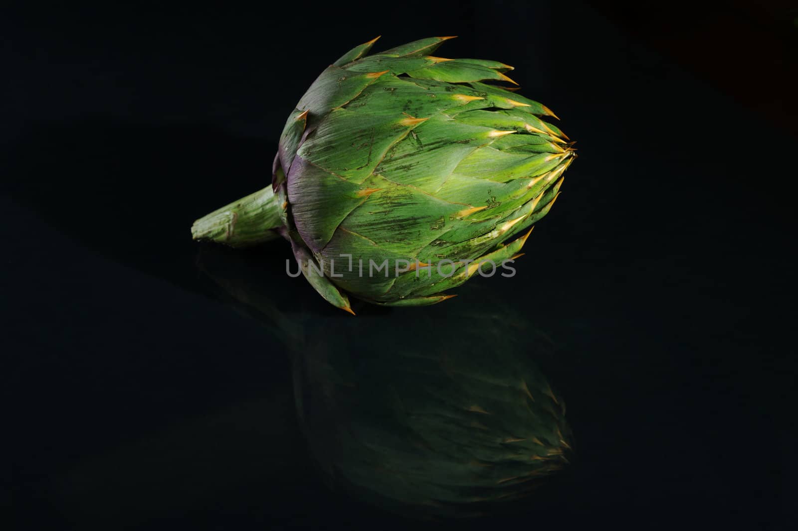 Green artichoke and its reflection on black (Selective Focus)