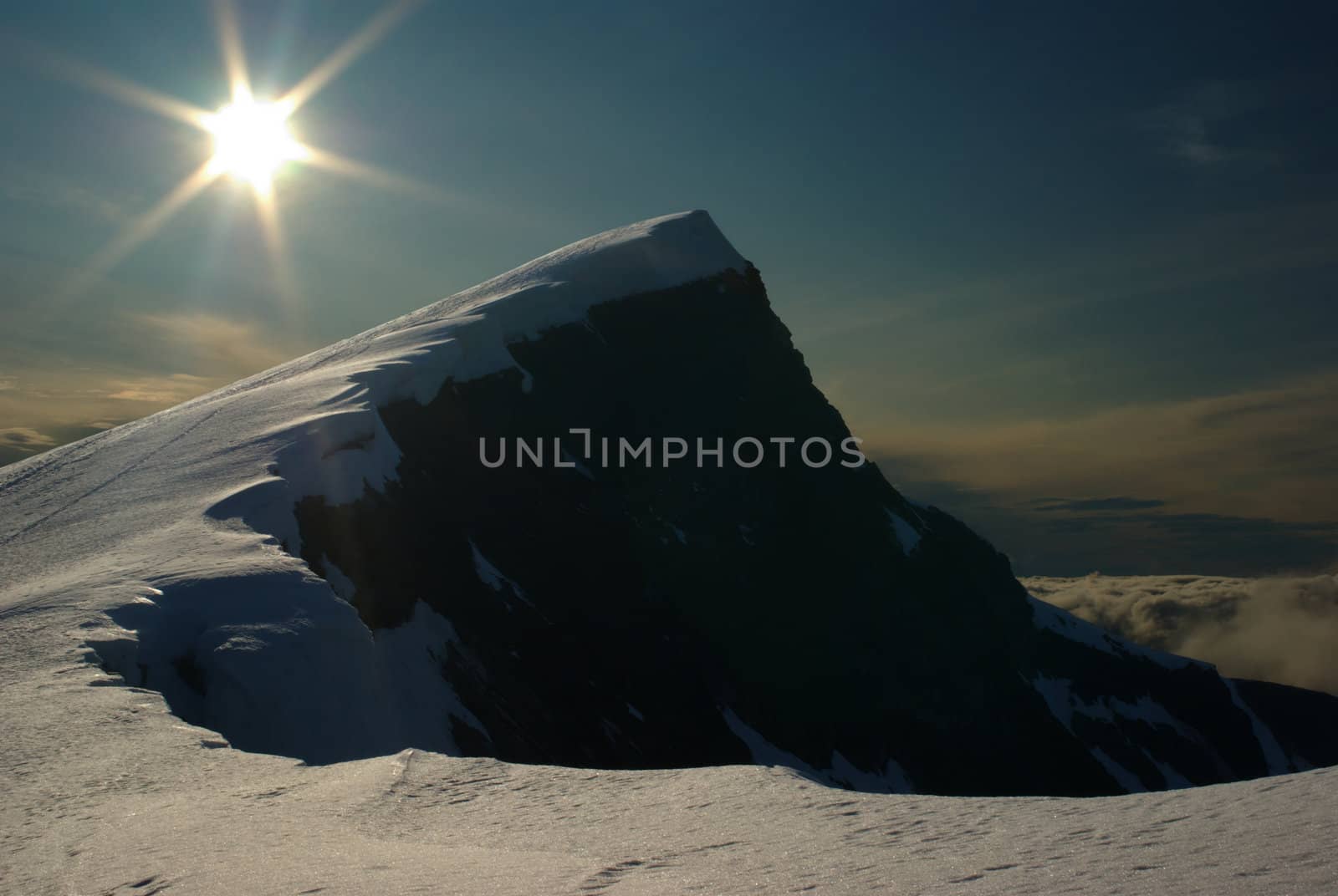 The summit of the snow-covered Glittertind (second highest peak in Norway) and the setting sun 