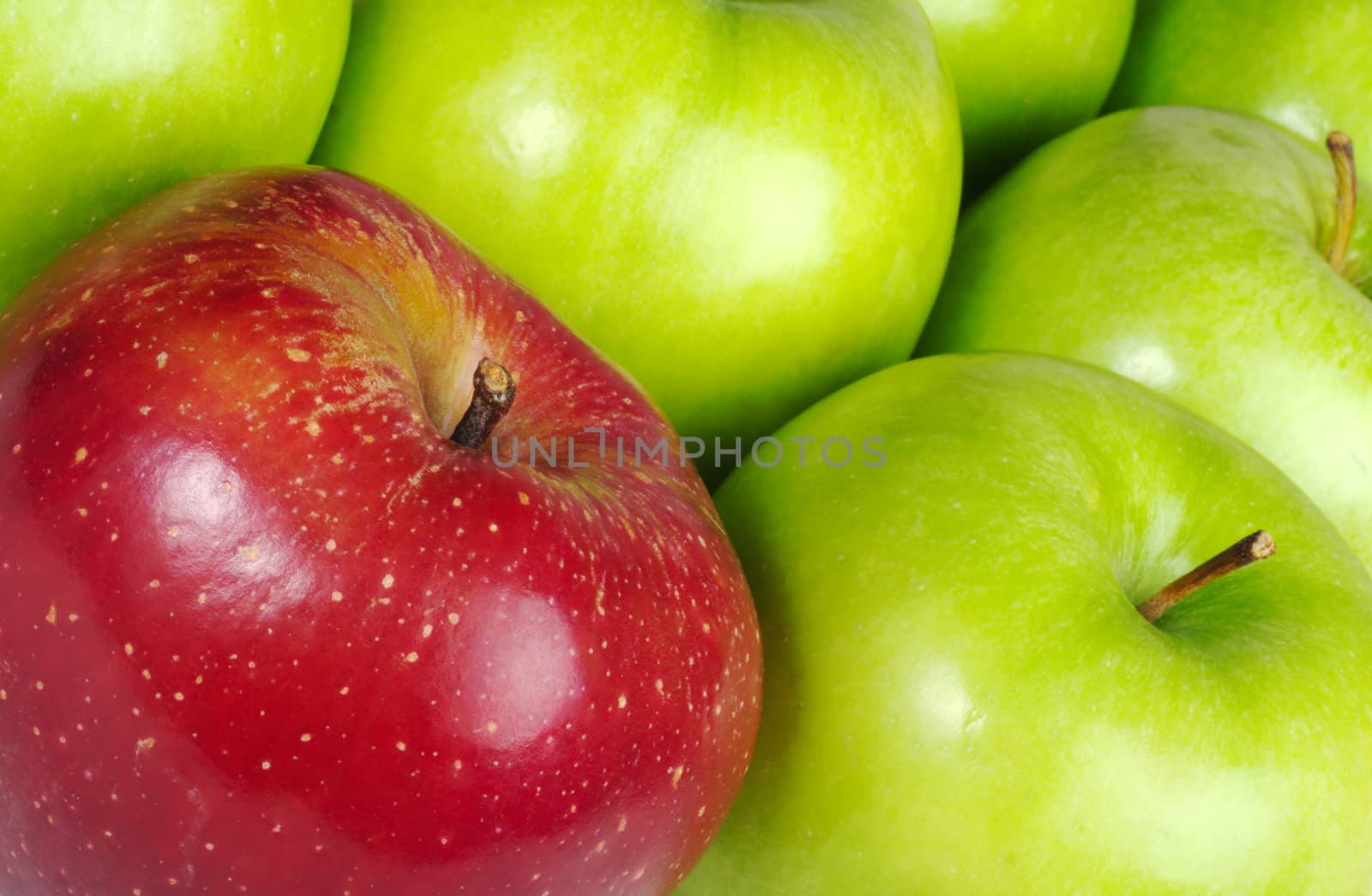 Red colored Apple in between many green Apples (Selective Focus, Close-Up, tilted)