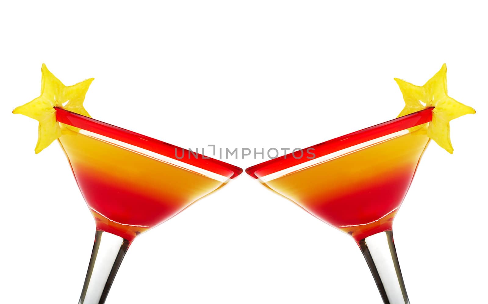 Toasting with Tequila Sunrise in red-rimmed cocktail glass garnished with a star-fruit slice on white (Selective focus)