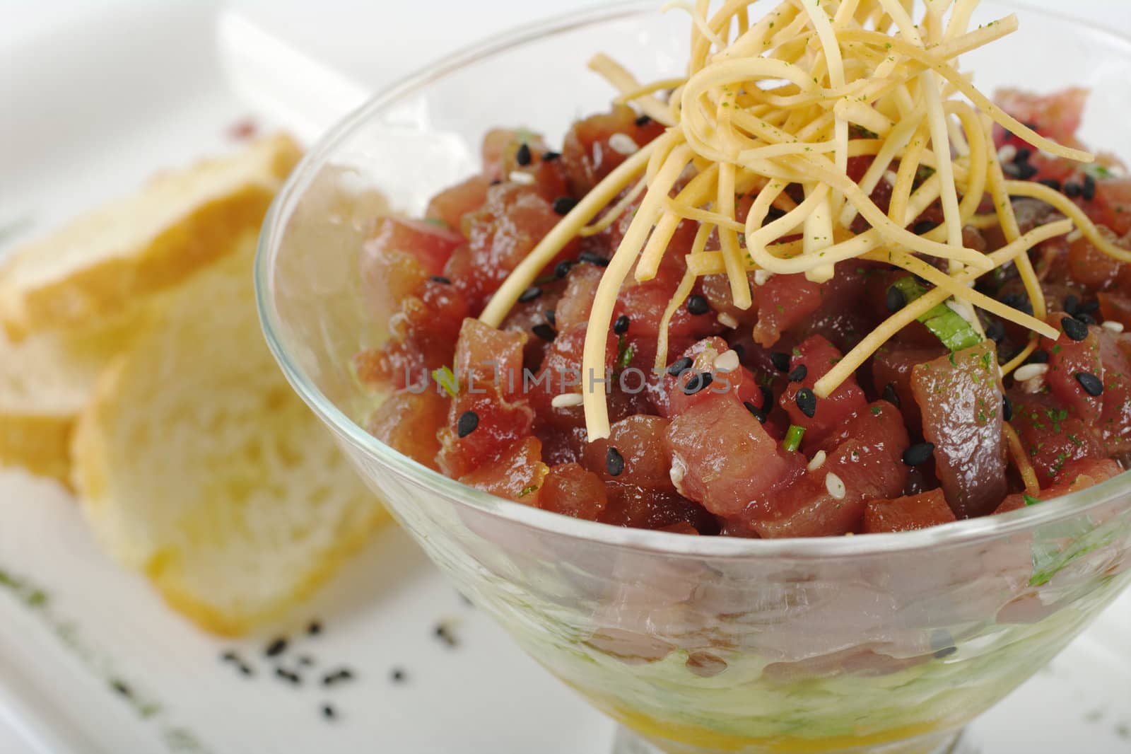 Appetizer: Raw Tuna, Avocado and Mango in Glass with Baguette Slices in the Background (Selective Focus)