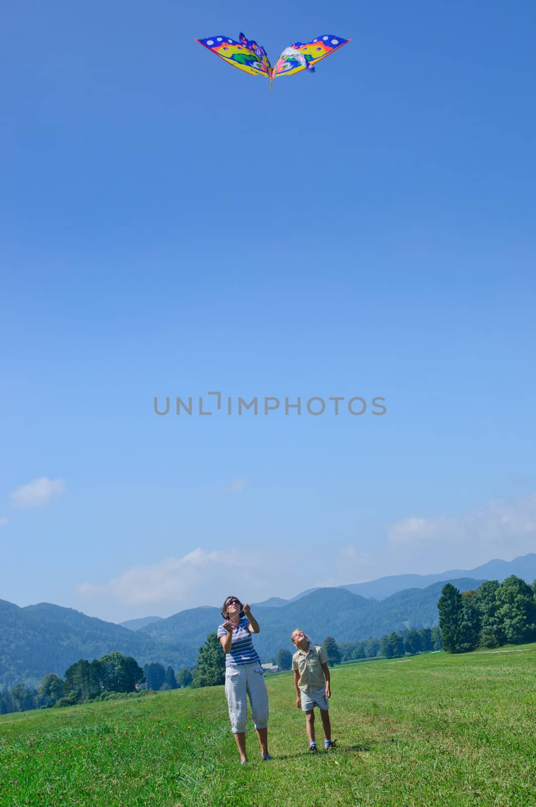 Mom and daughter play a kite in the Alps