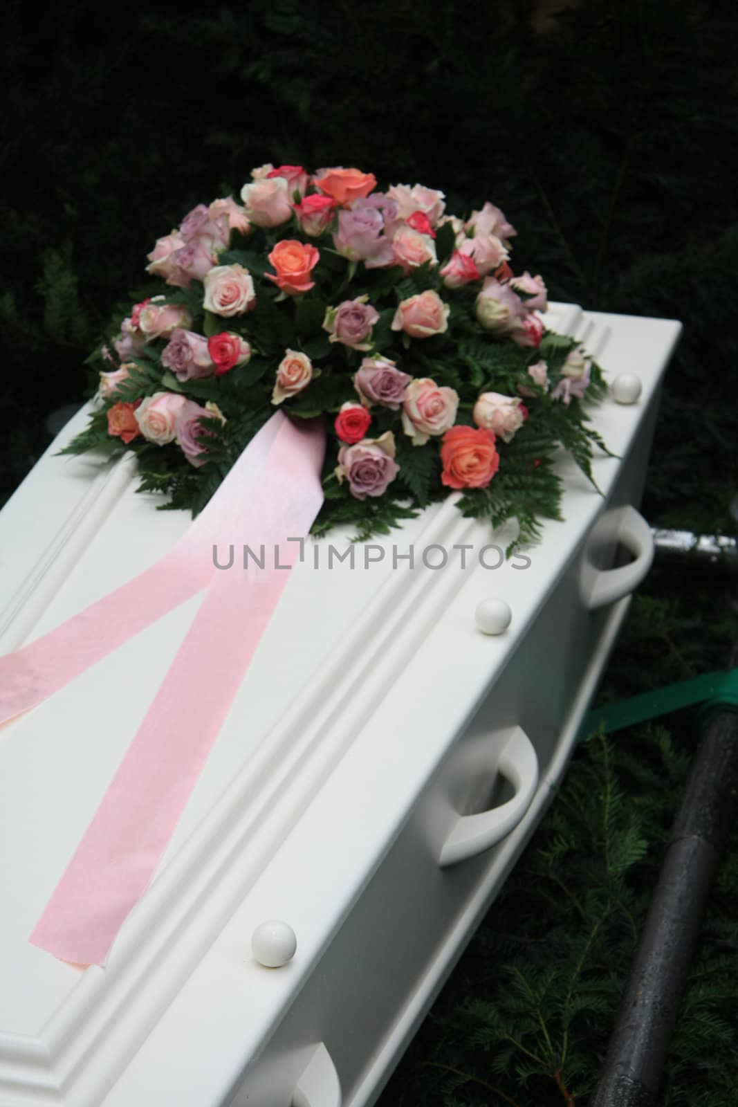 pink sympathy flowers on a white coffin by studioportosabbia