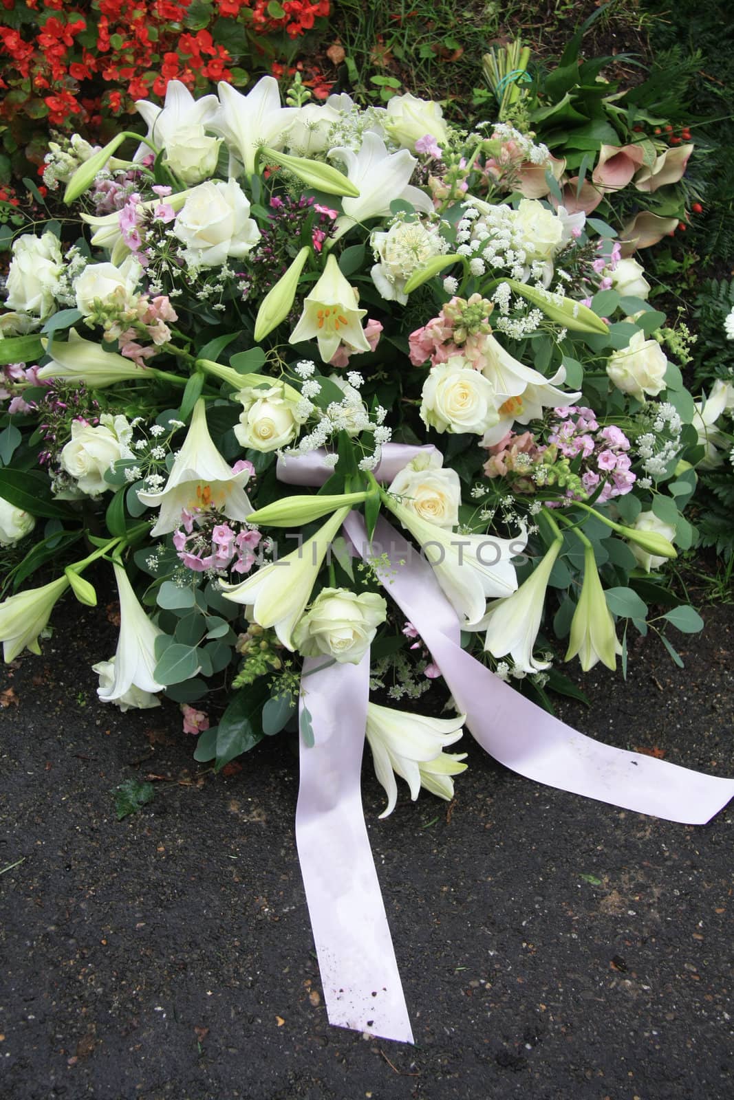 A white sympathy floral arrangement near a grave