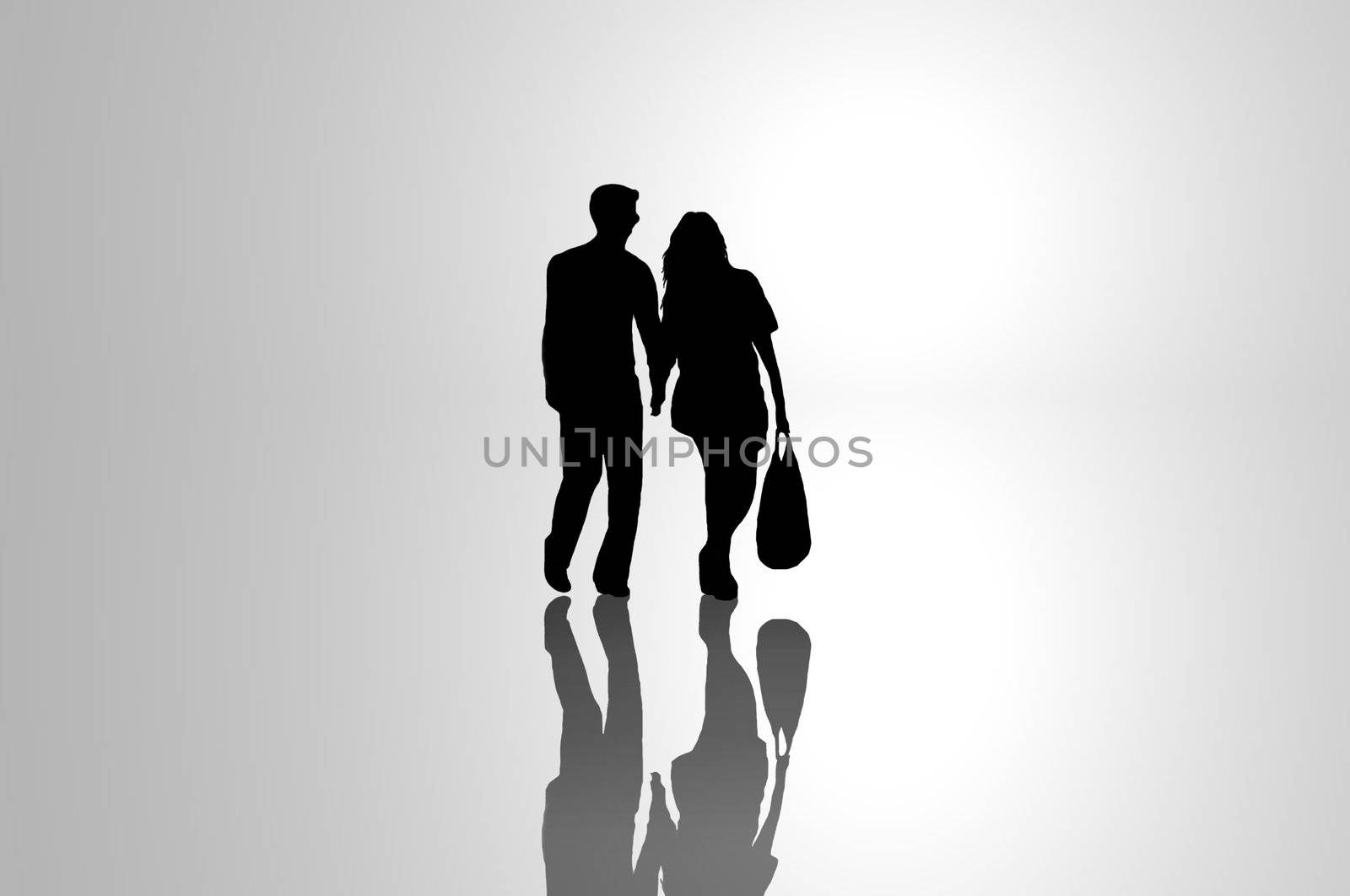 A silhouetted young couple walking on reflective surface towards a bright light with grey background.