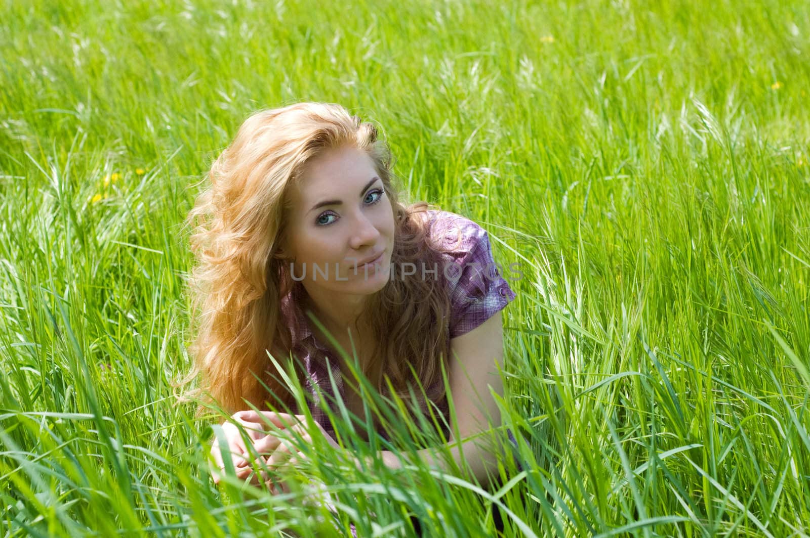Redheaded woman among green grass